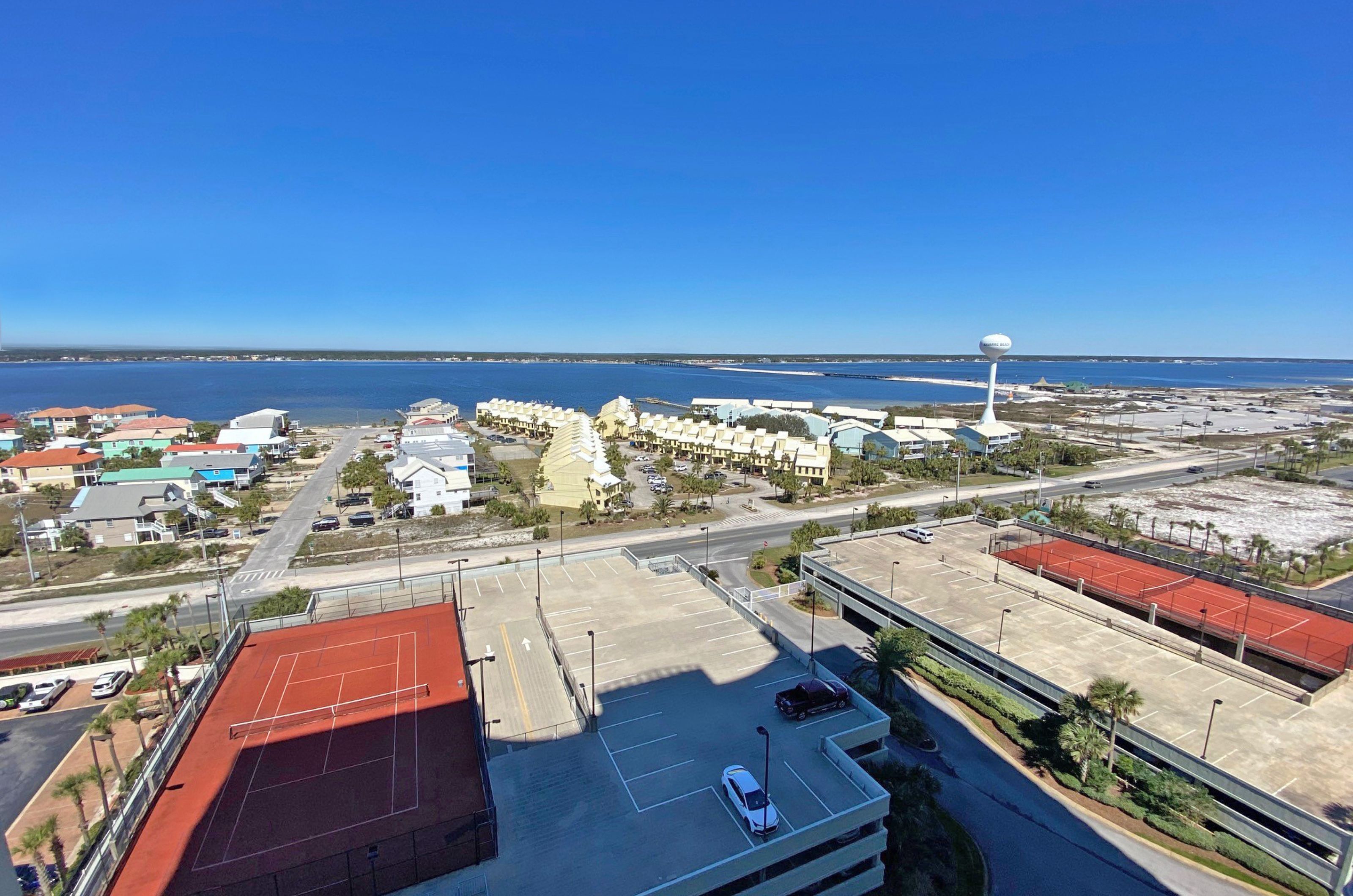 Aerial view of two outdoor tennis courts and complimentary parking garages 