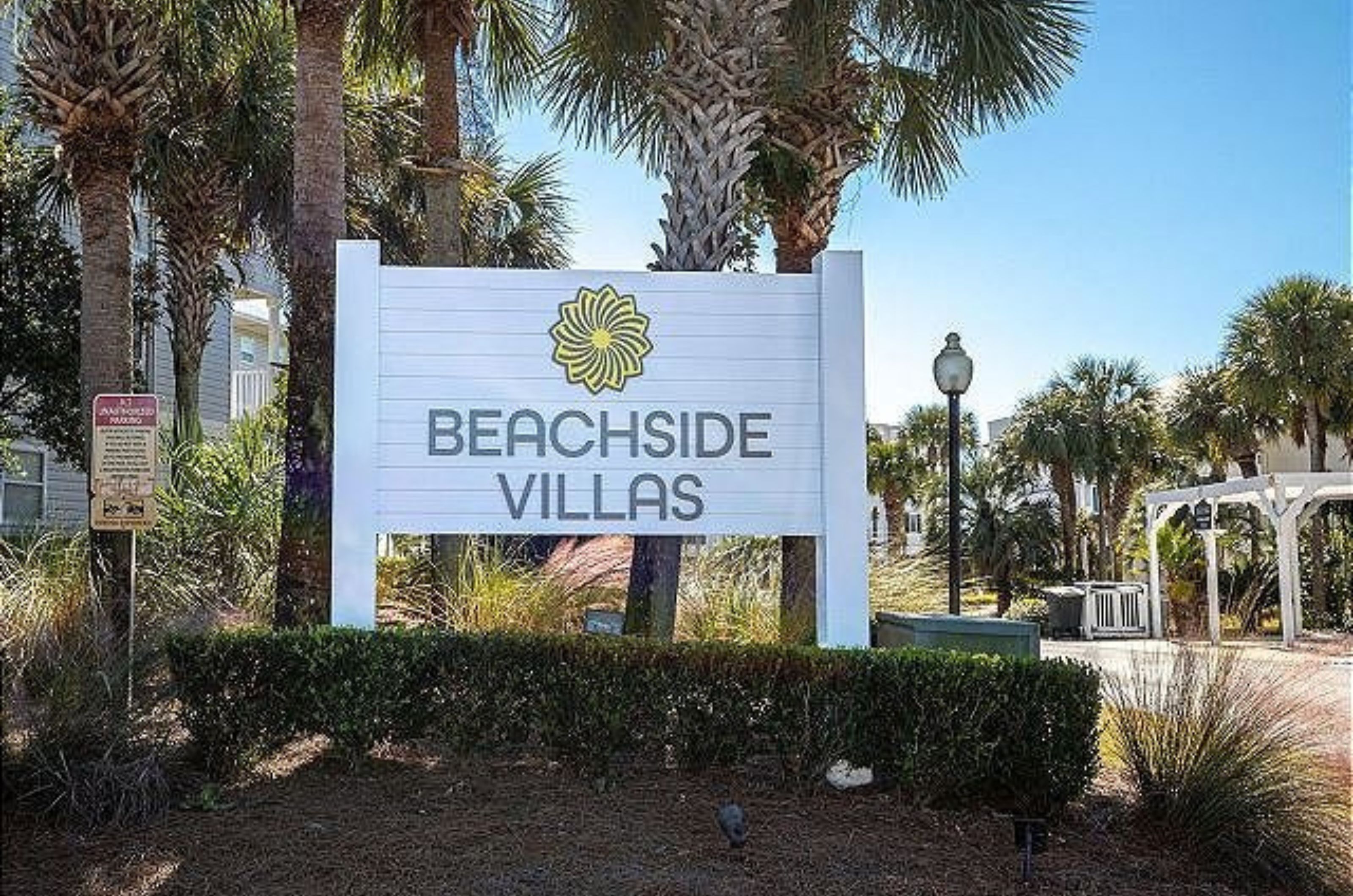 The property's entry sign with the condos behind it at Beachside Villas in Seagrove Beach Florida 