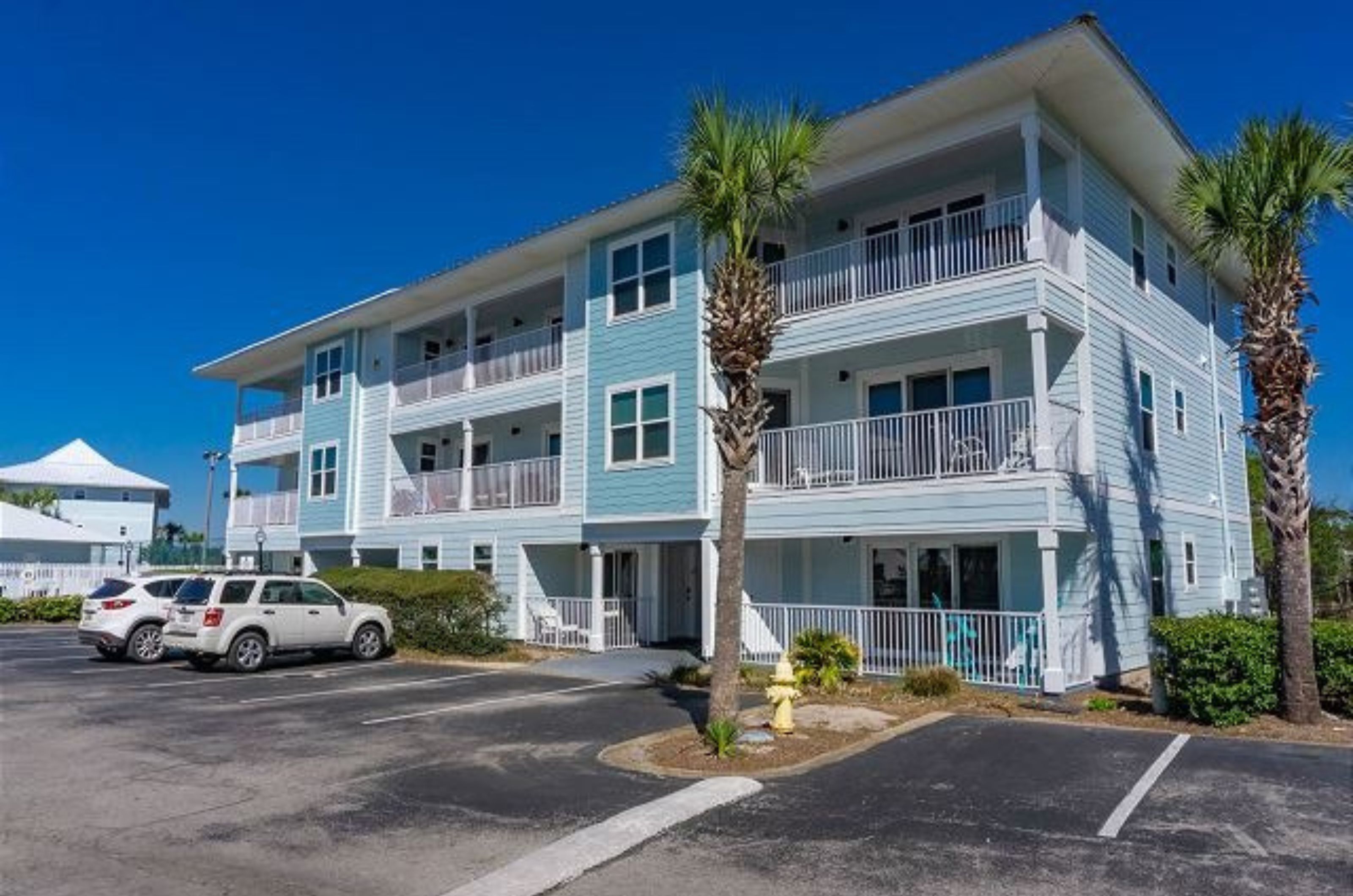 View from the parking lot of the exterior of Beachside Villas with private balconies 