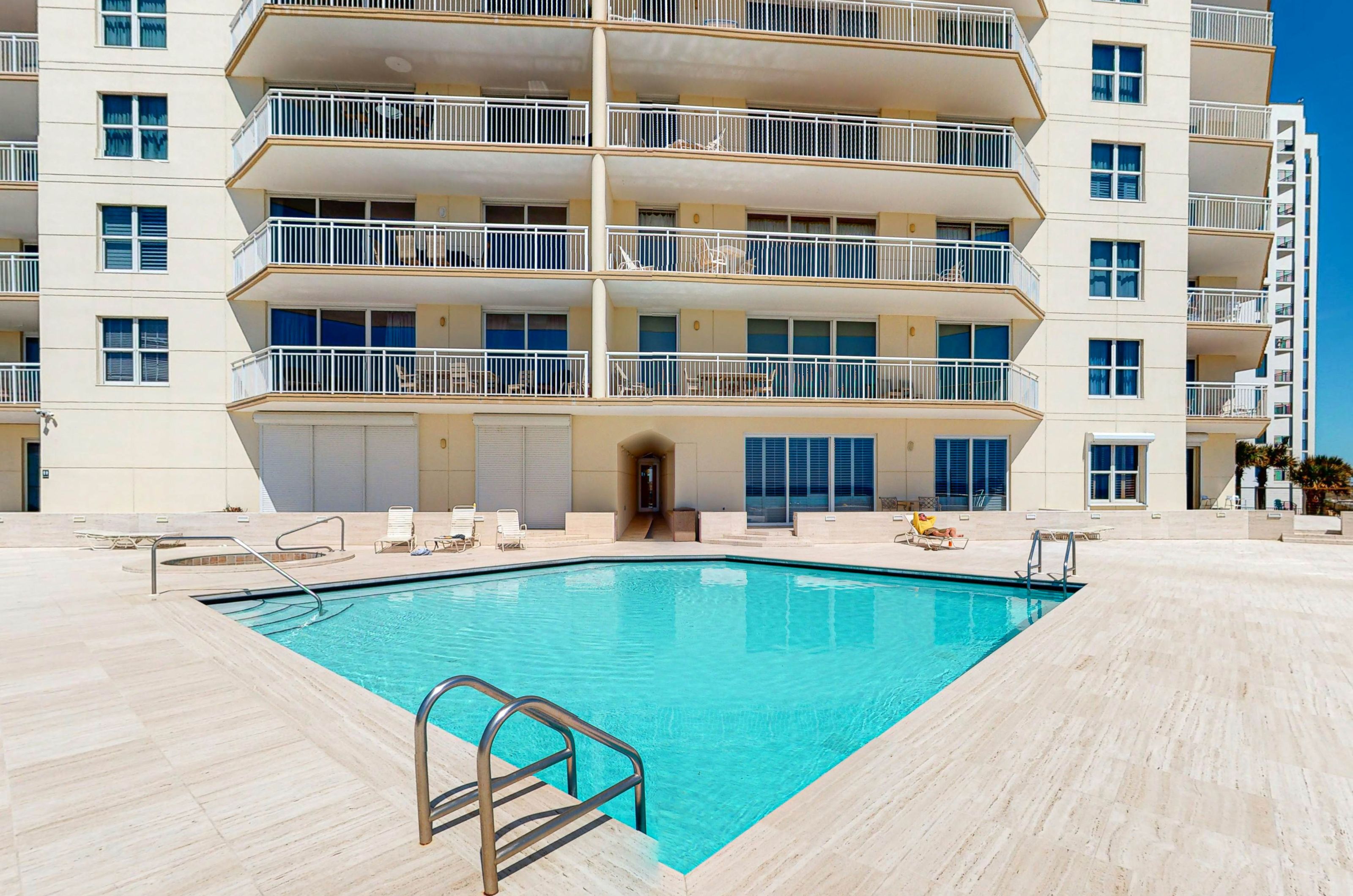 The outdoor pool with lounge chairs and a spacious pool deck 