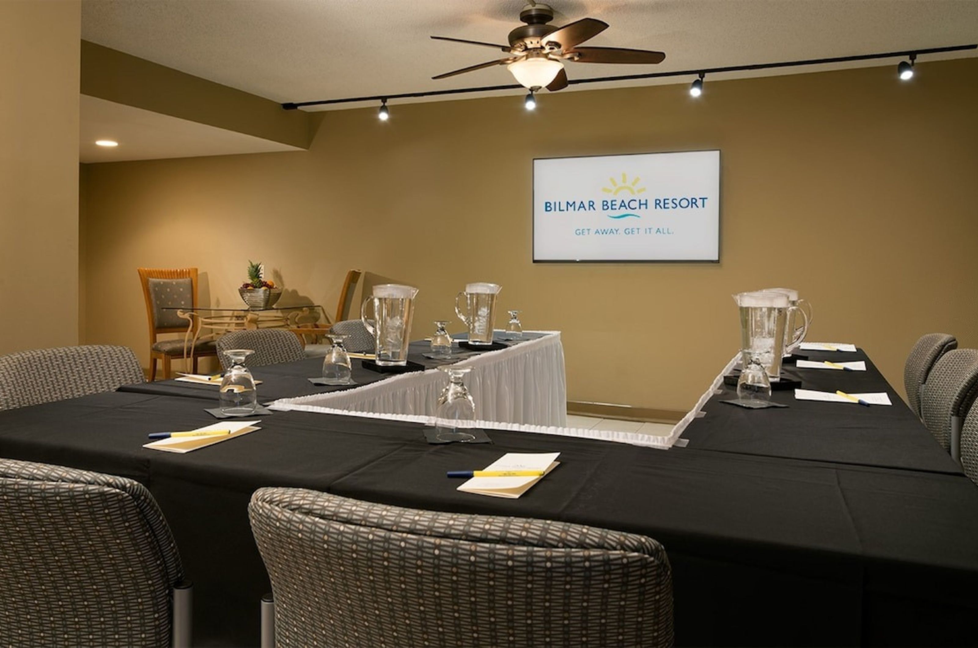 U-shaped table facing a large presentation screen in the meeting room 