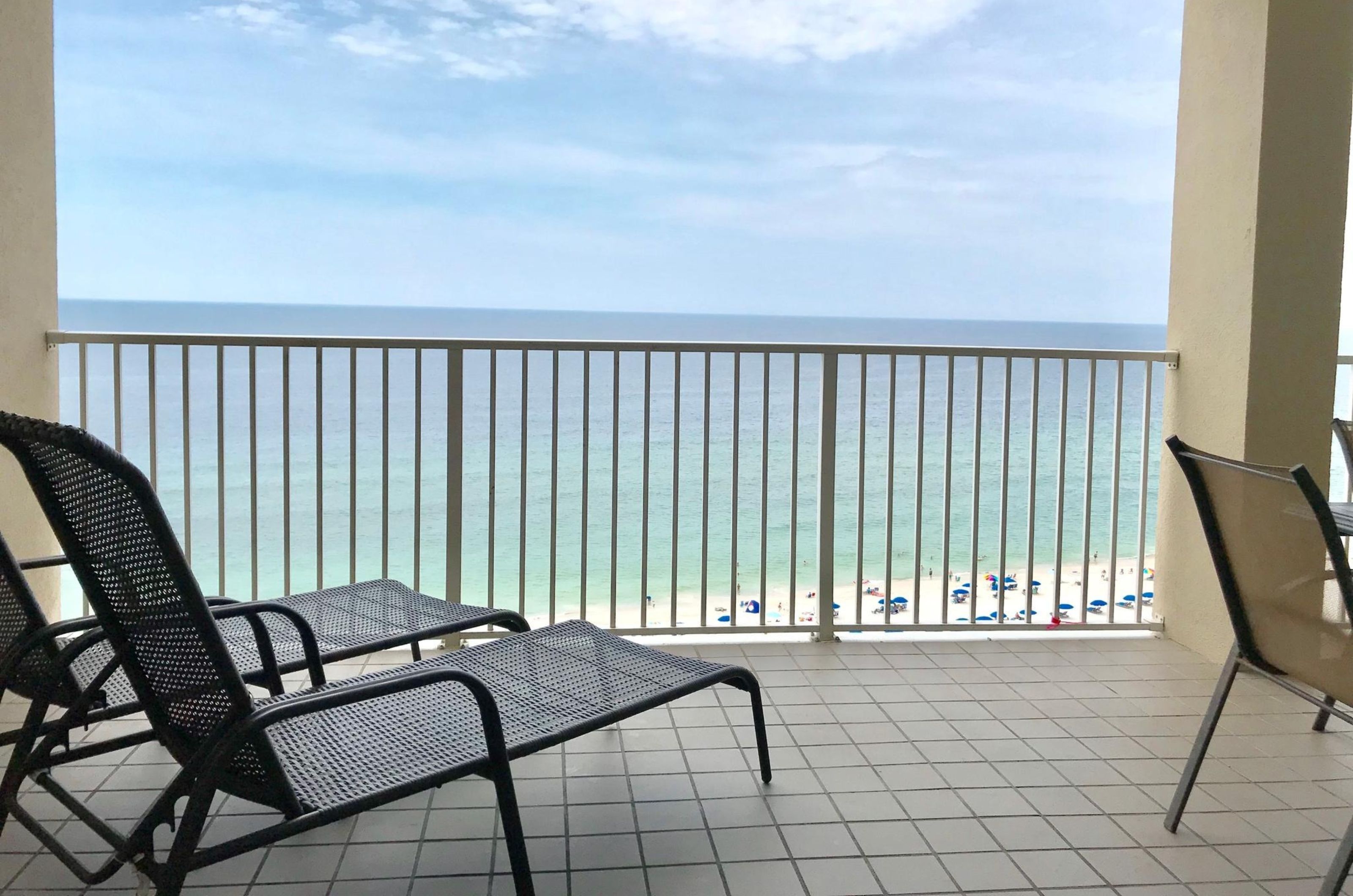 A private balcony overlooking the Gulf with lounge and dining chairs