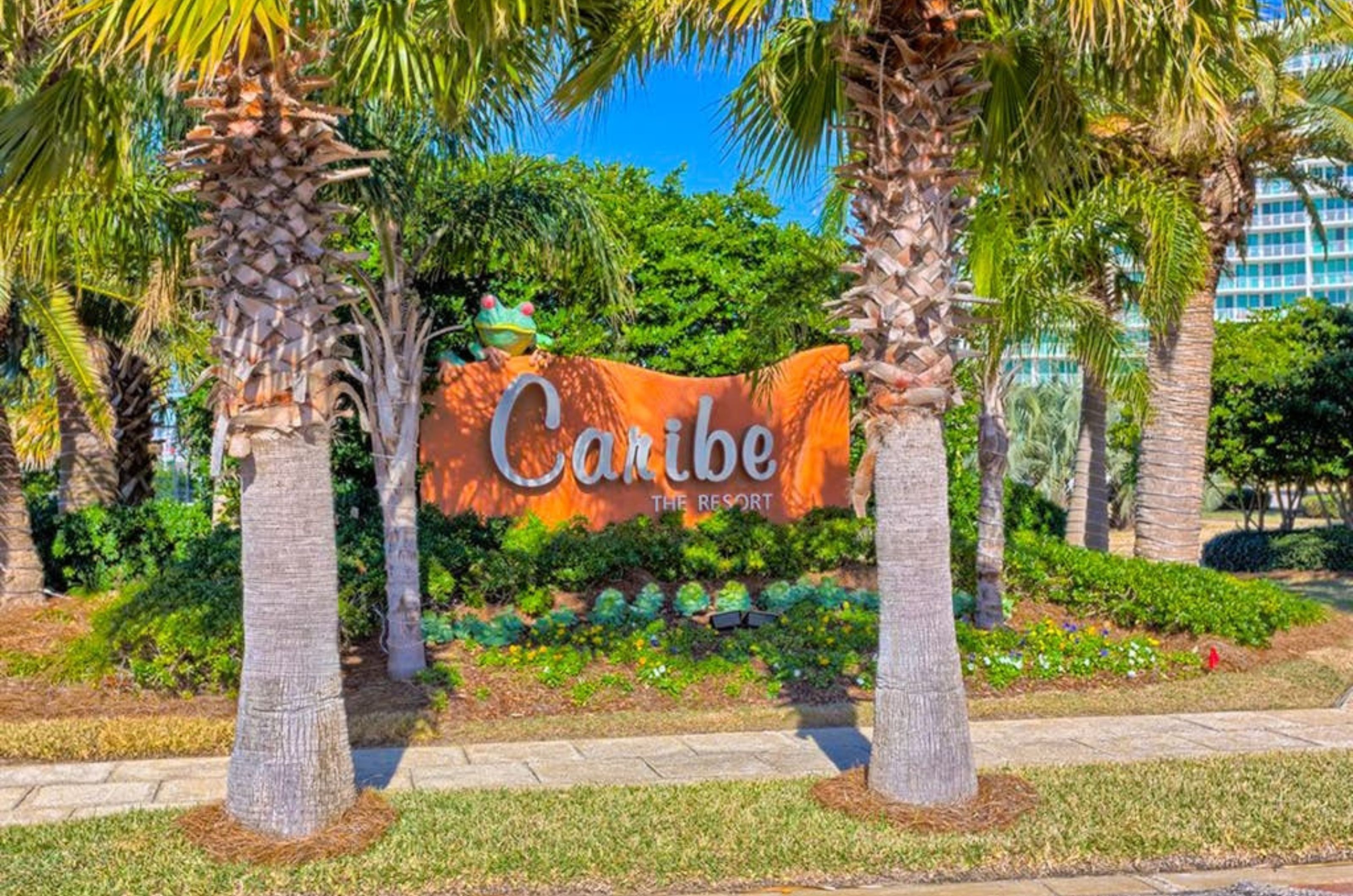 The property's entrance sign surrounded by a tropical landscape 