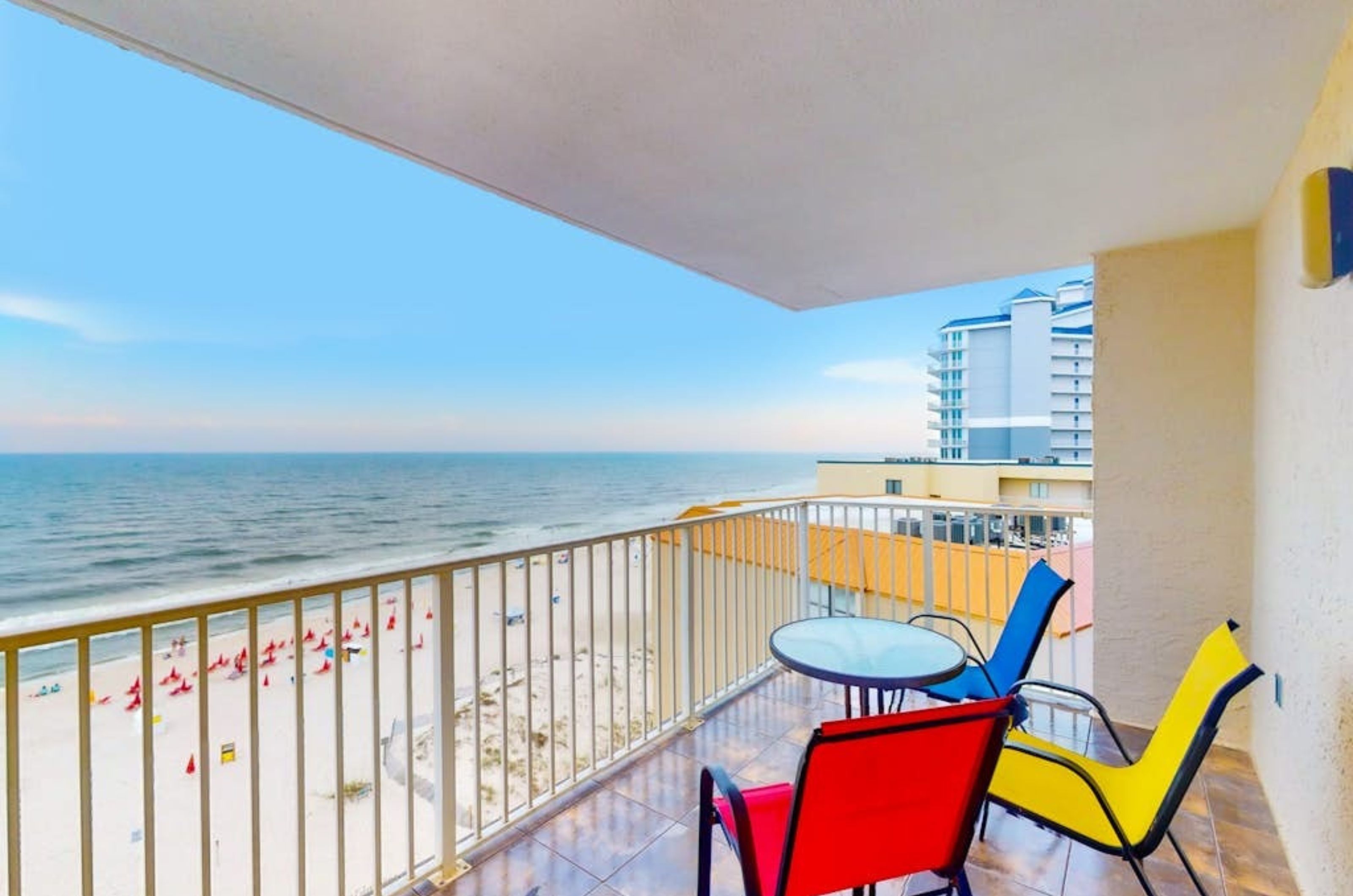 A private balcony overlooking the Gulf with chairs and a small table at Clearwater Condos