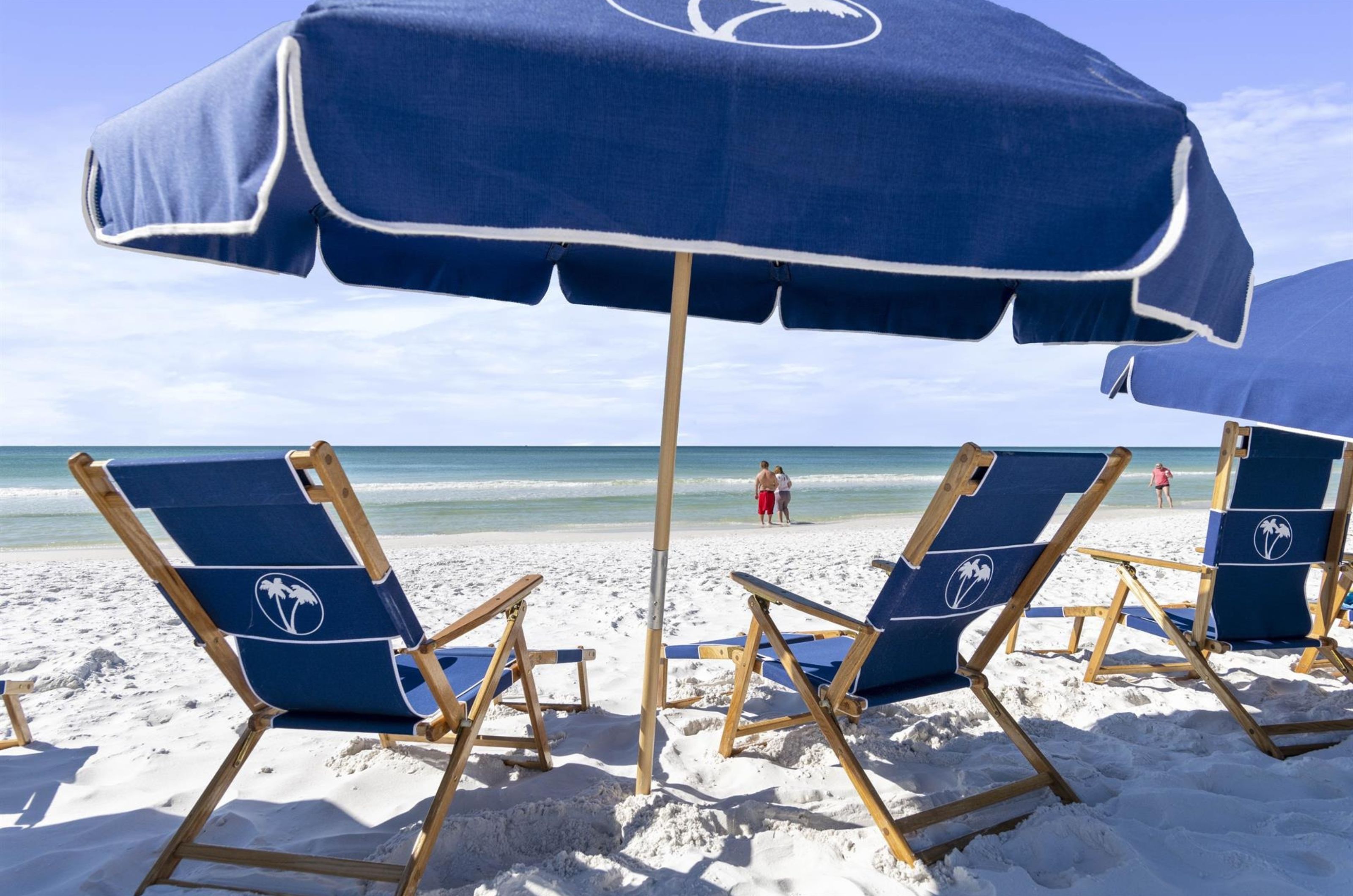 Two chairs next to an umbrella on the beach at Destin Beach Club in Destin Florida	