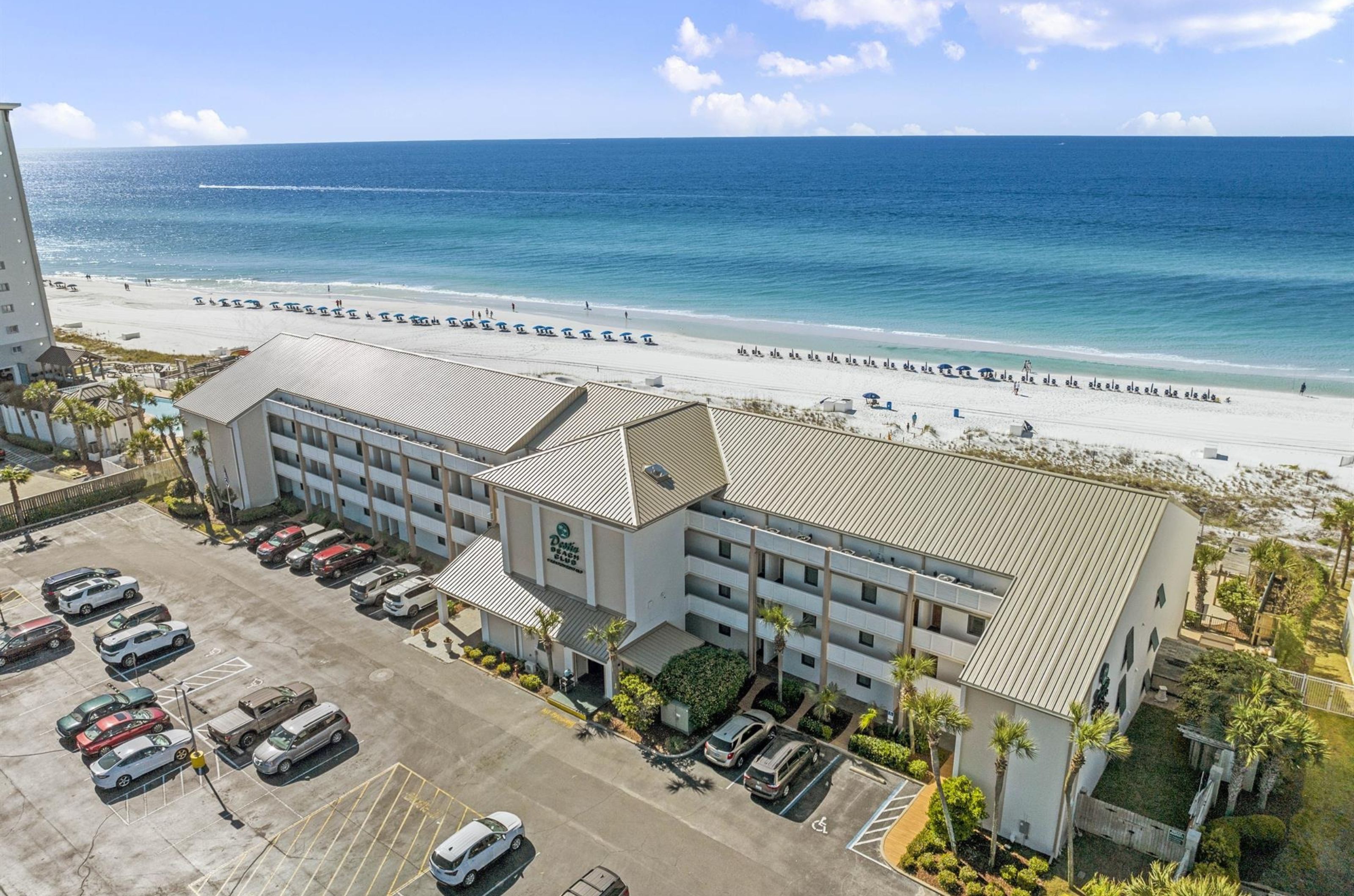 Aerial view from the street side of Destin Beach Club with the parking lot in front 