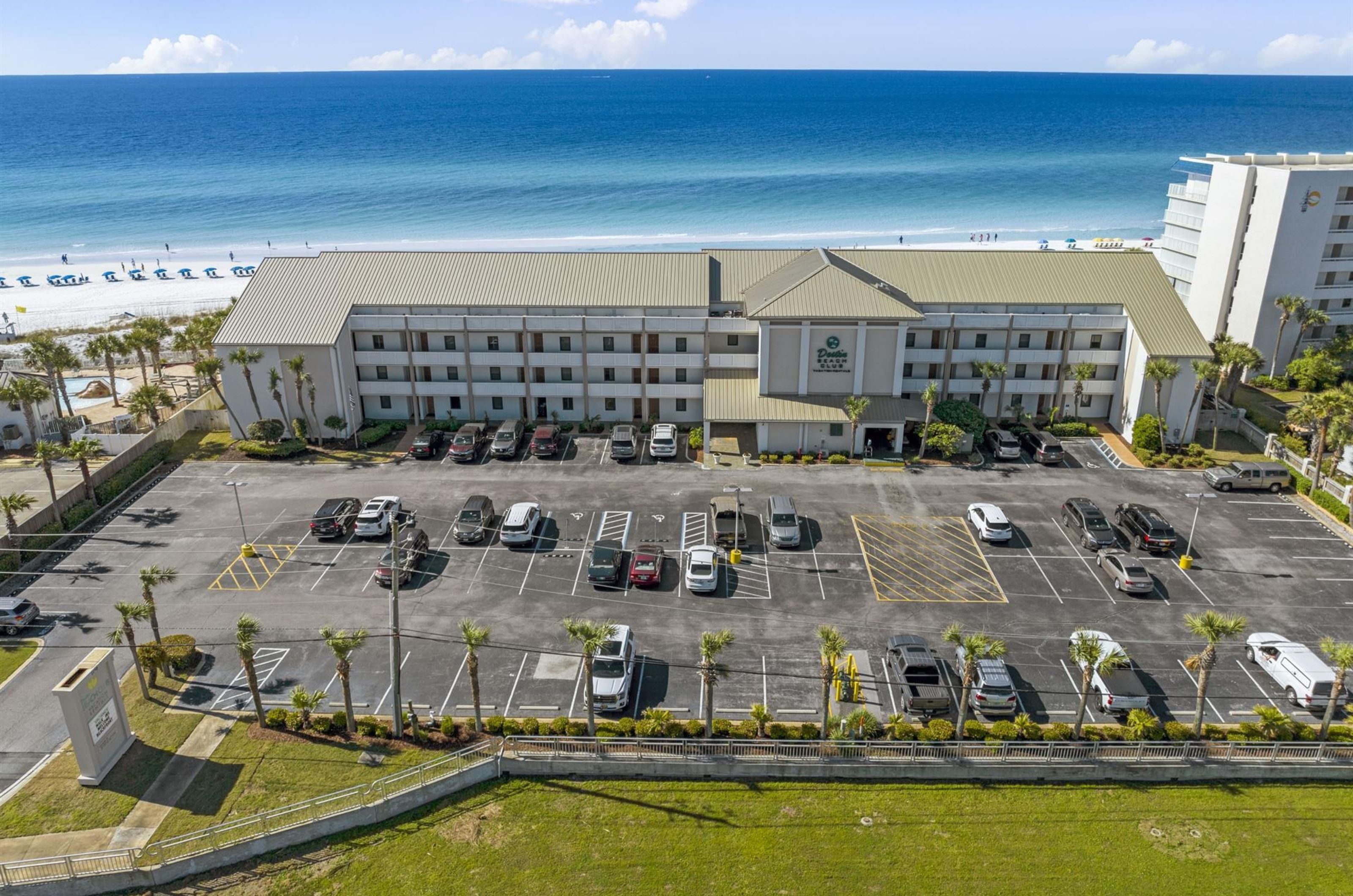 View from the street of the parking lot and Destin Beach Club in Destin Florida