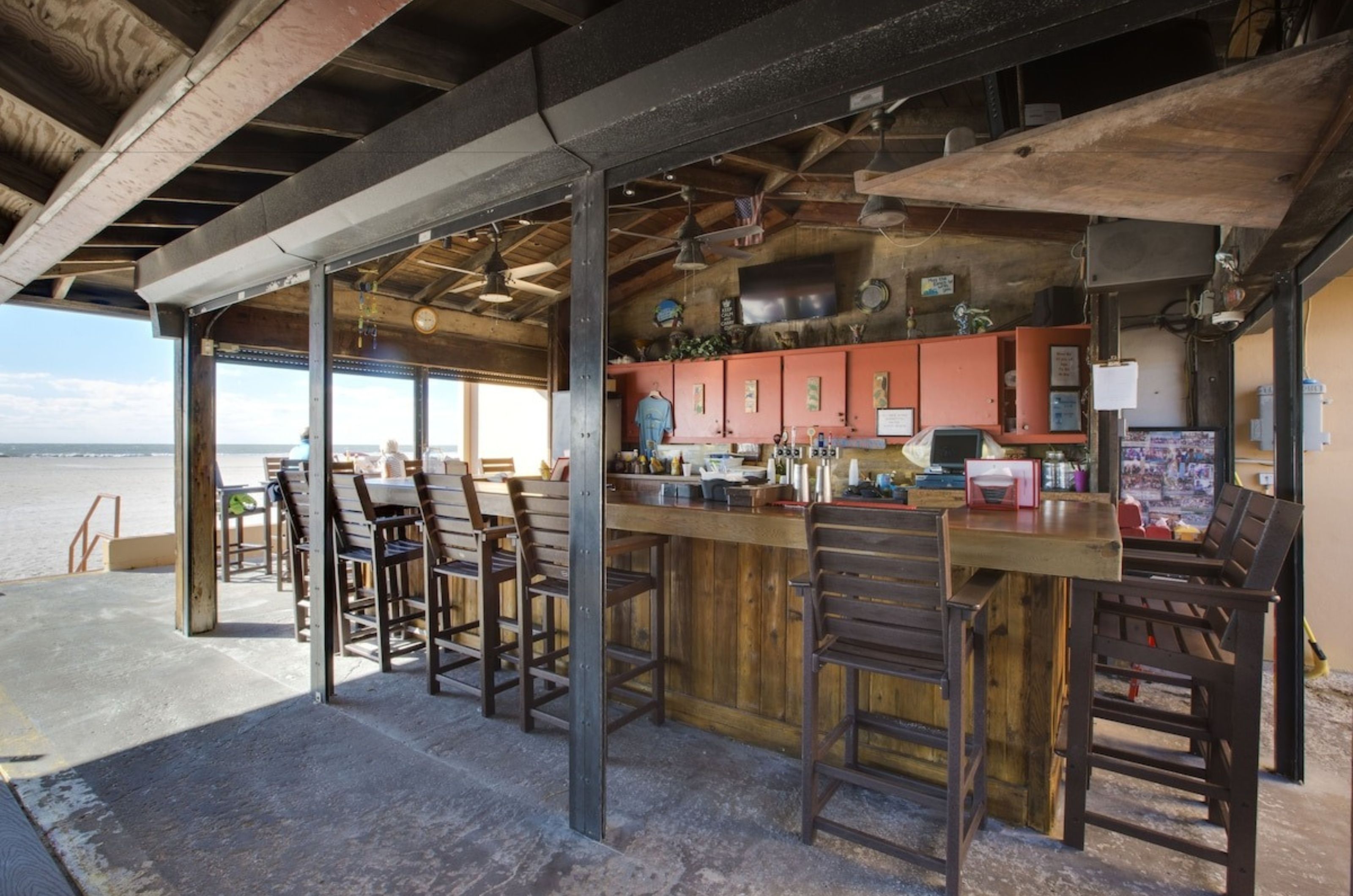 The covered poolside bar with bar stools	