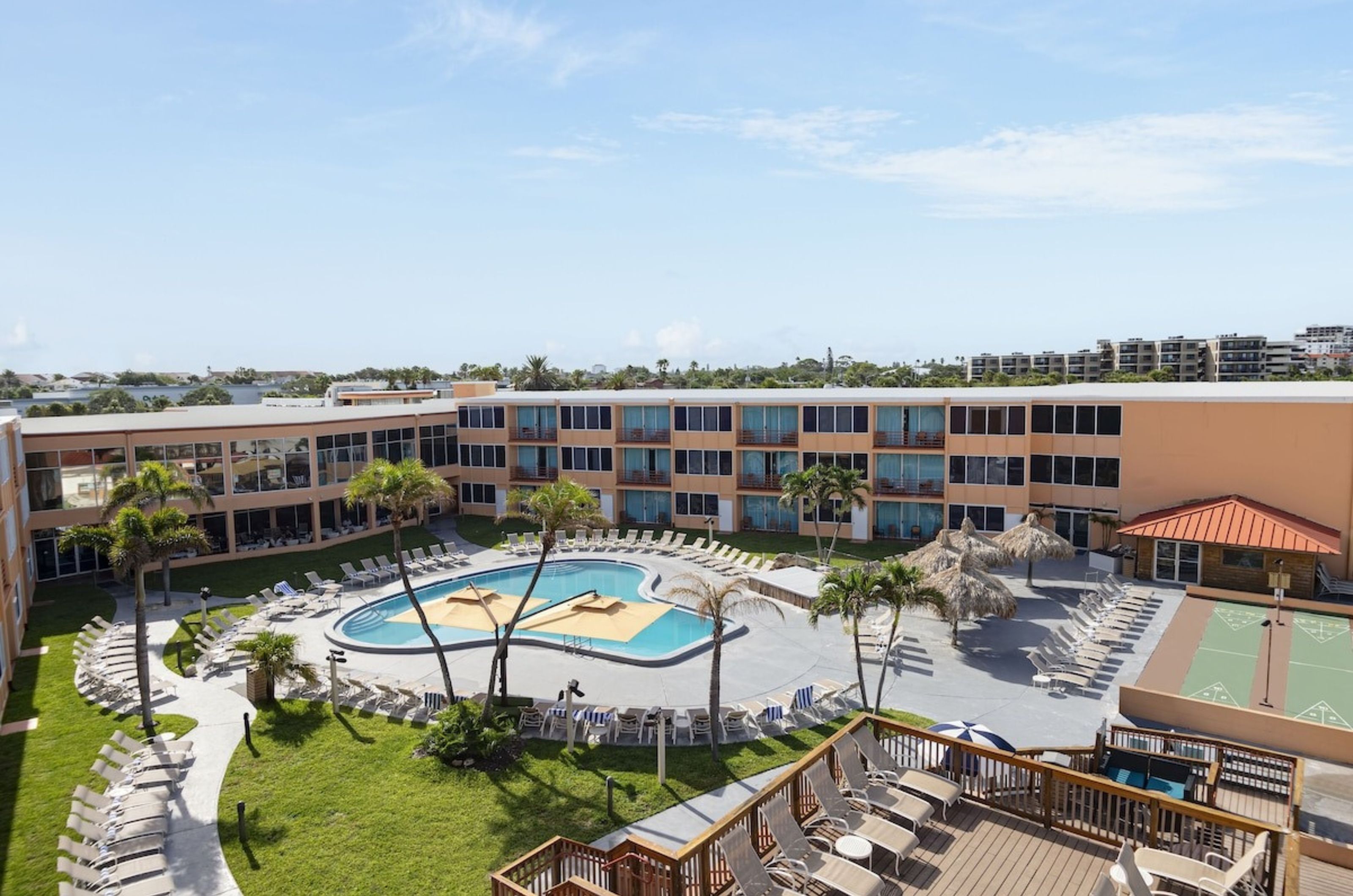 Aerial view of the pool and shuffledboard courts in front of Dolphin Beach Resort	