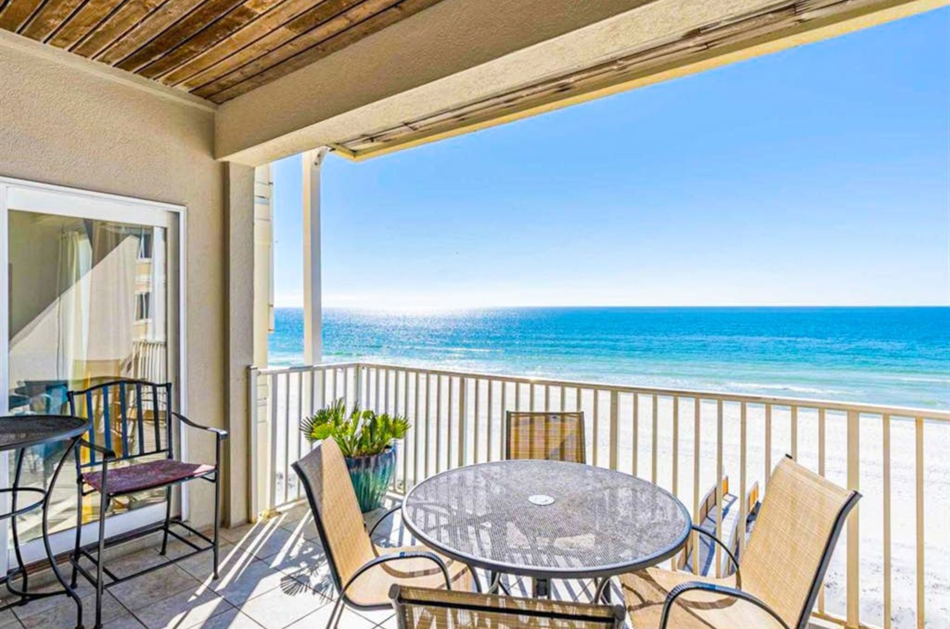 A private balcony with a dining table and chairs overlooking the Gulf at Dolphin Key 