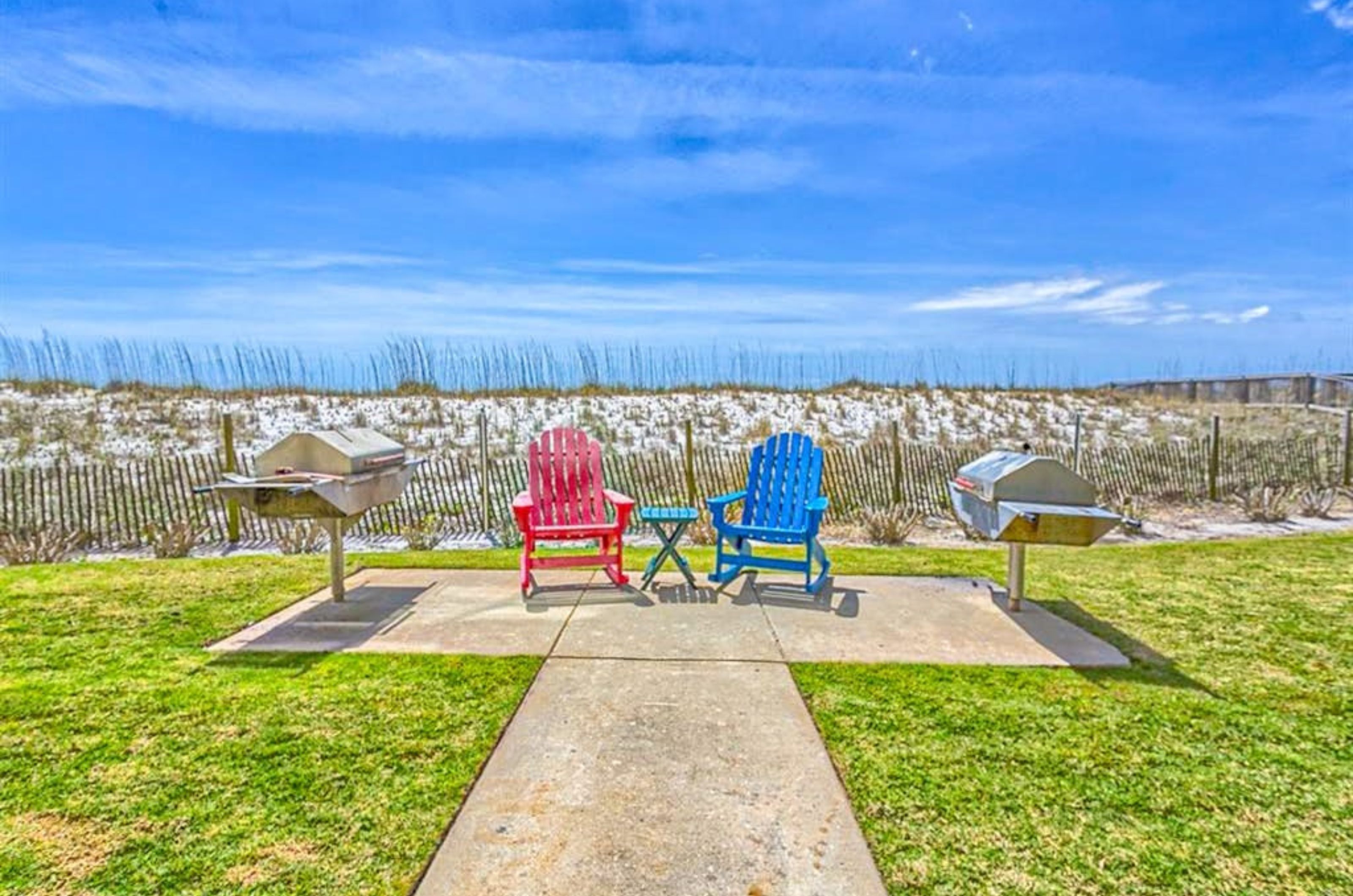 Beachisde barbecue grills next to lounge chairs at Dolphin Key in Orange Beach Alabama 