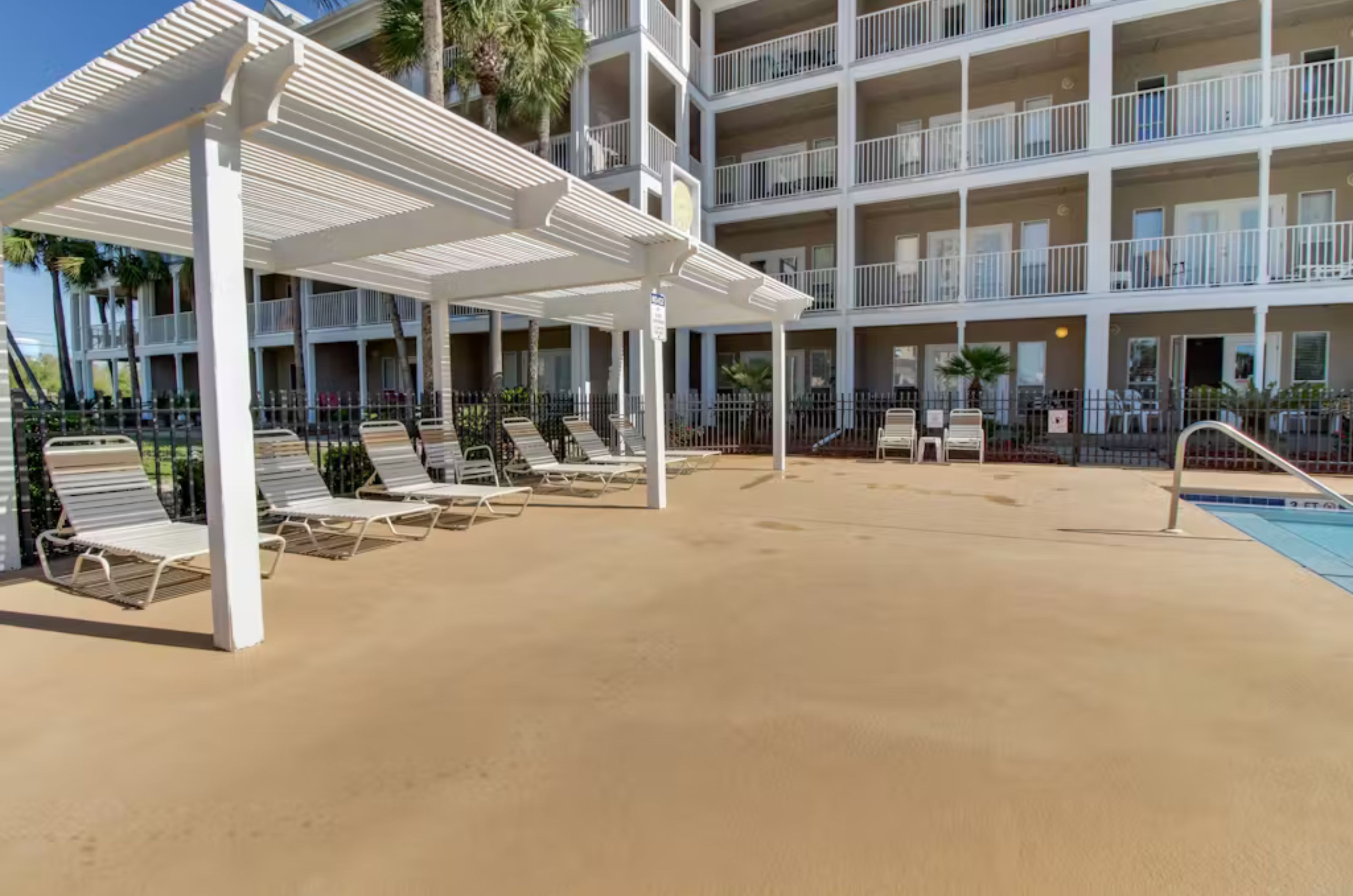 Poolside loungechairs under an awning in front of Grand Caribbean