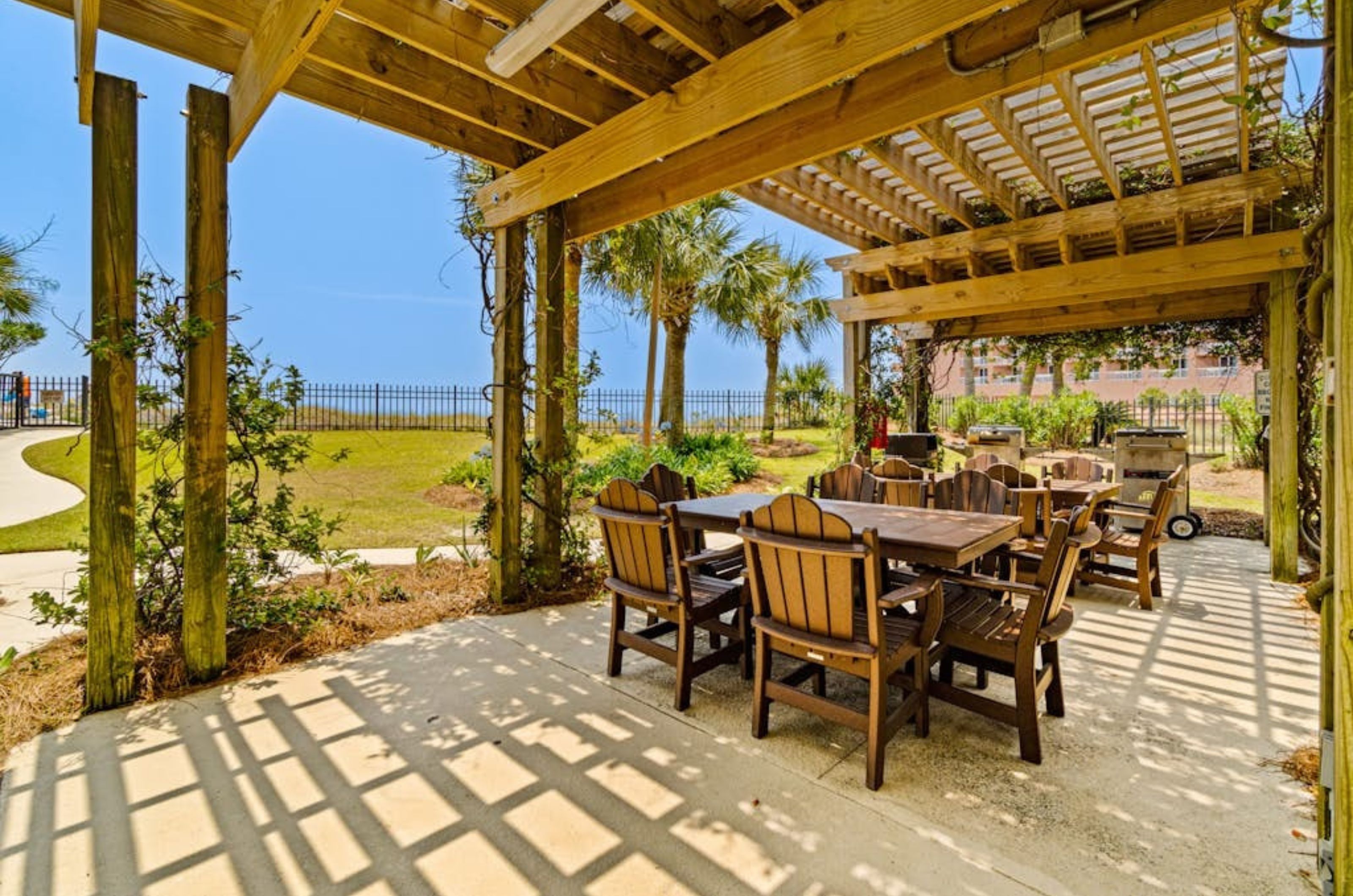 A covered terrace next to the beach wtih grills and picnic tables at Grand Poine