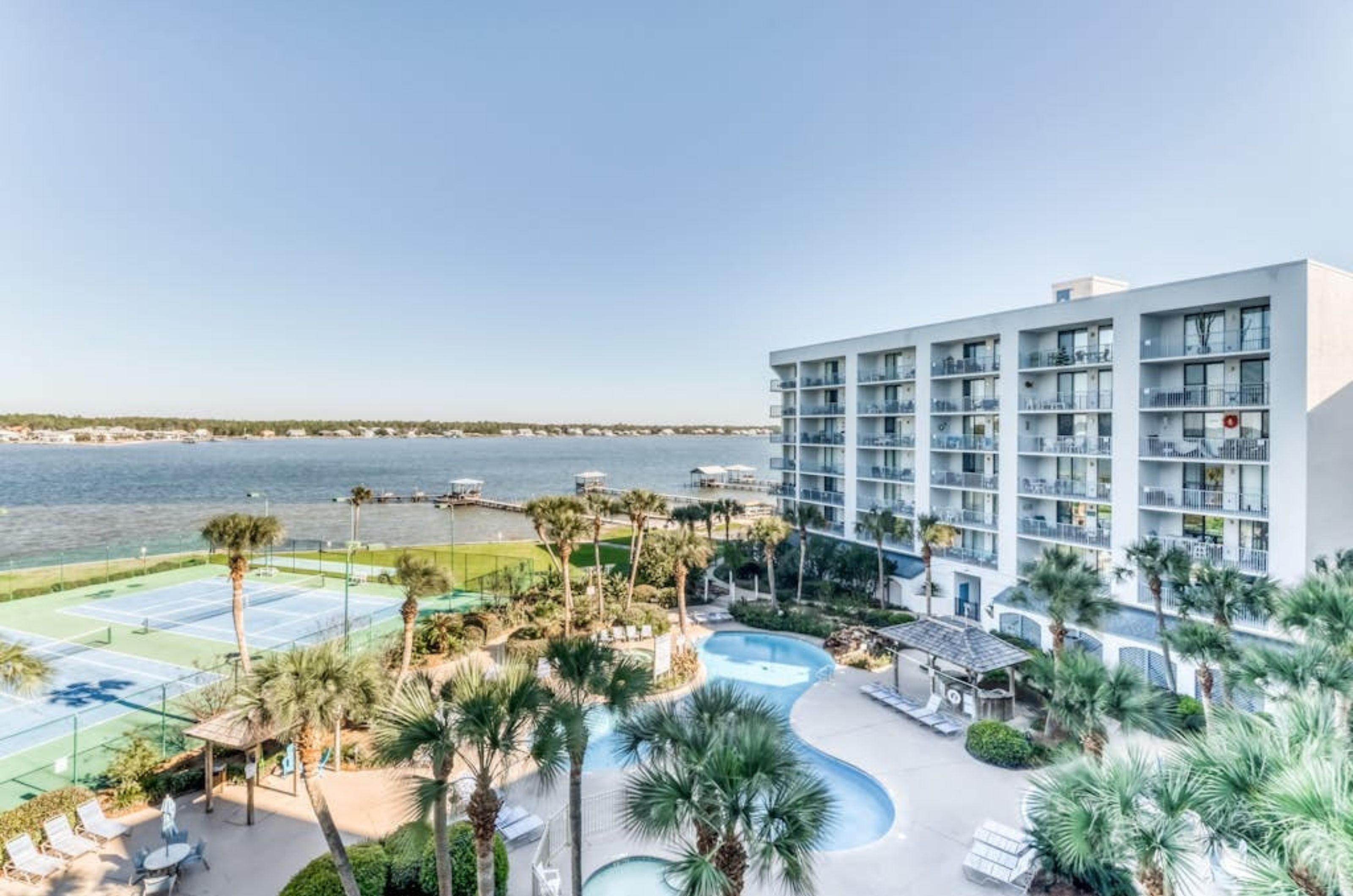 View from a private balcony of the pool deck tennis courts and Little Lagoon at Gulf Shores Surf and Racquet Club