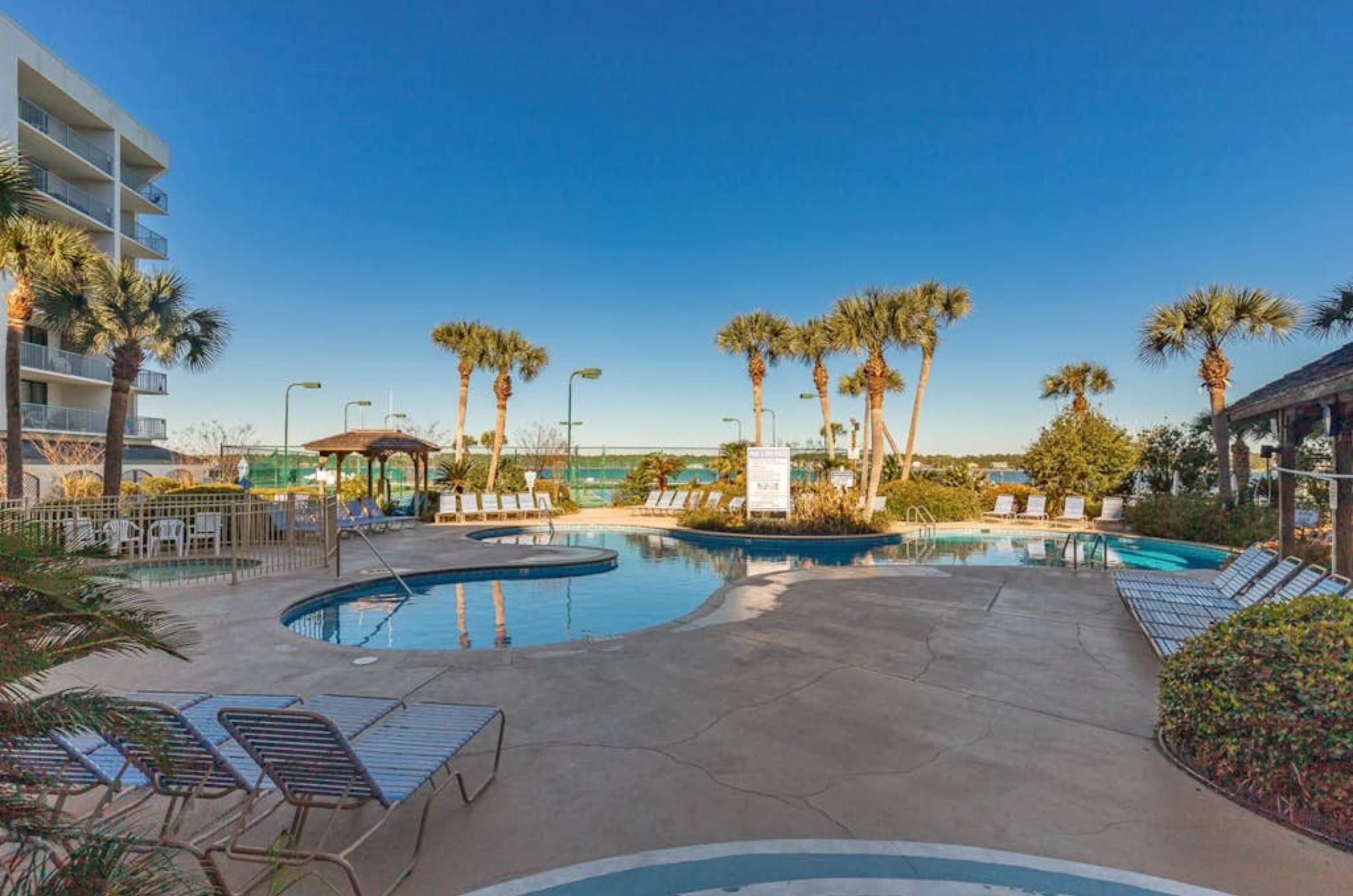 Lounge chairs on the pool deck by the outdoor pool at Gulf Shores Surf and Racquet Club 