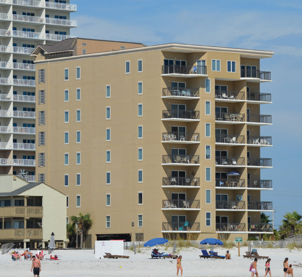 Beachgoers enjoying the sun and sand outside Legacy Gulf Shores