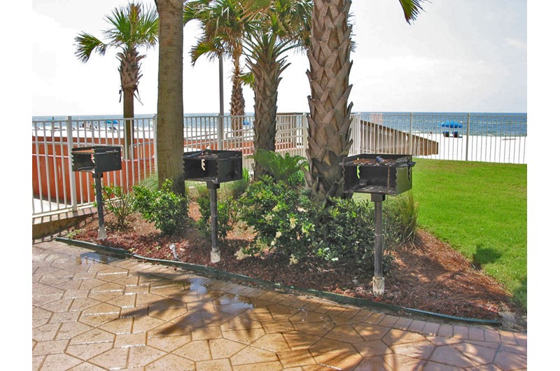 Grilling area with three grills and a view of the beach at Ocean House Gulf Shores