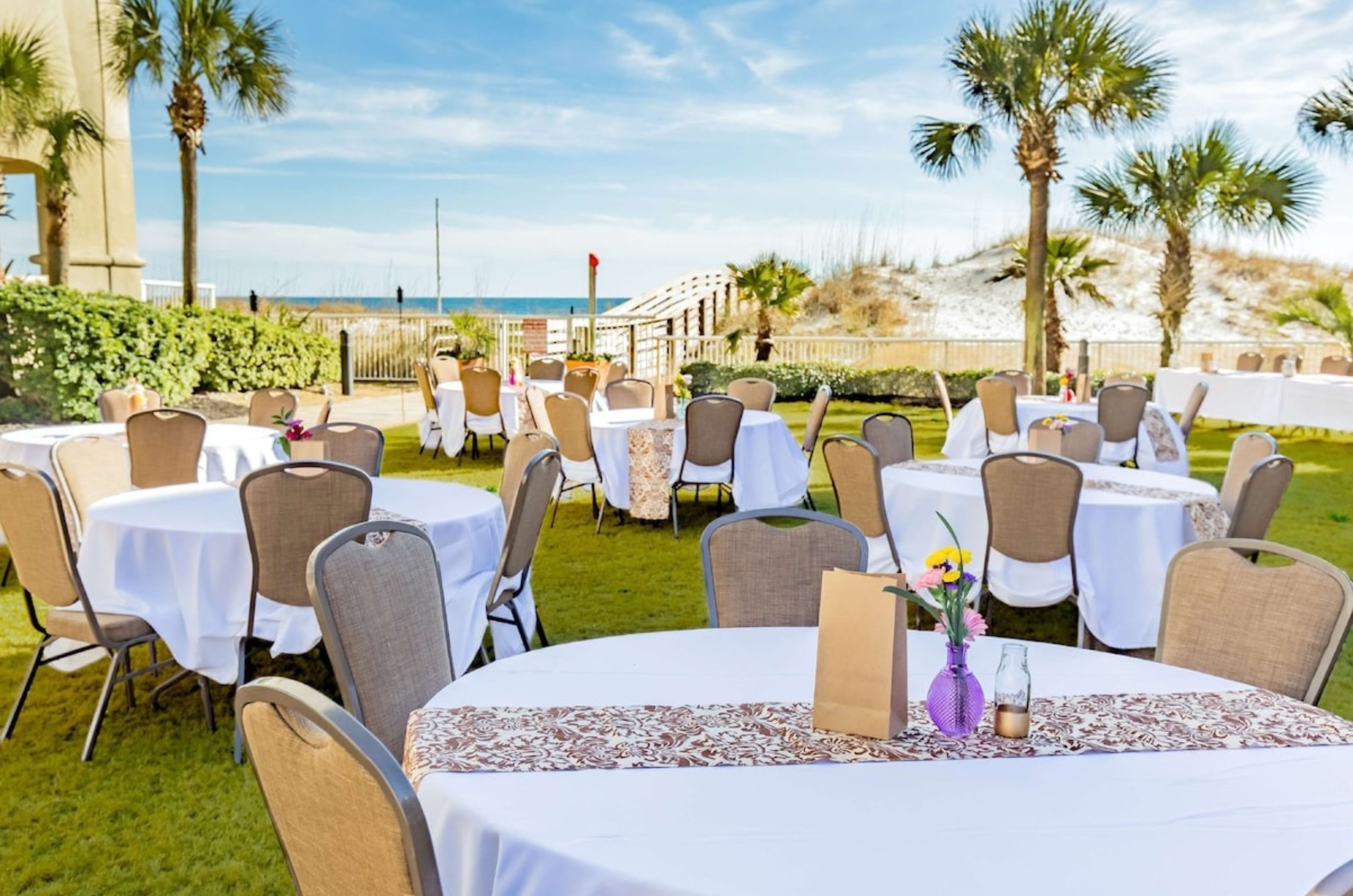 Dining tables and chairs on the beachside lawn at Hilton Garden Inn at Orange Beach Alabama 