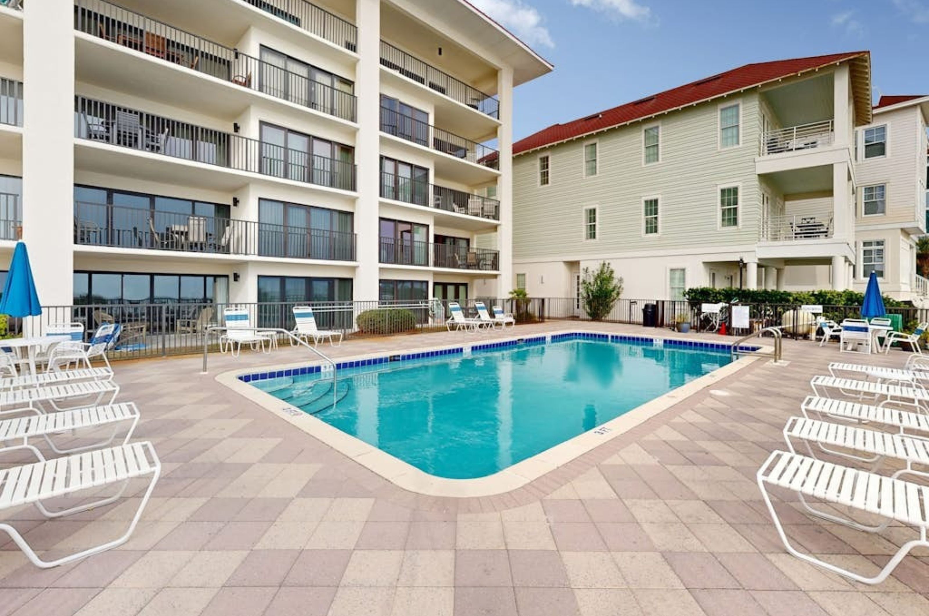 The outdoor pool and poolside lounge chairs in front of Huntington by the Sea 