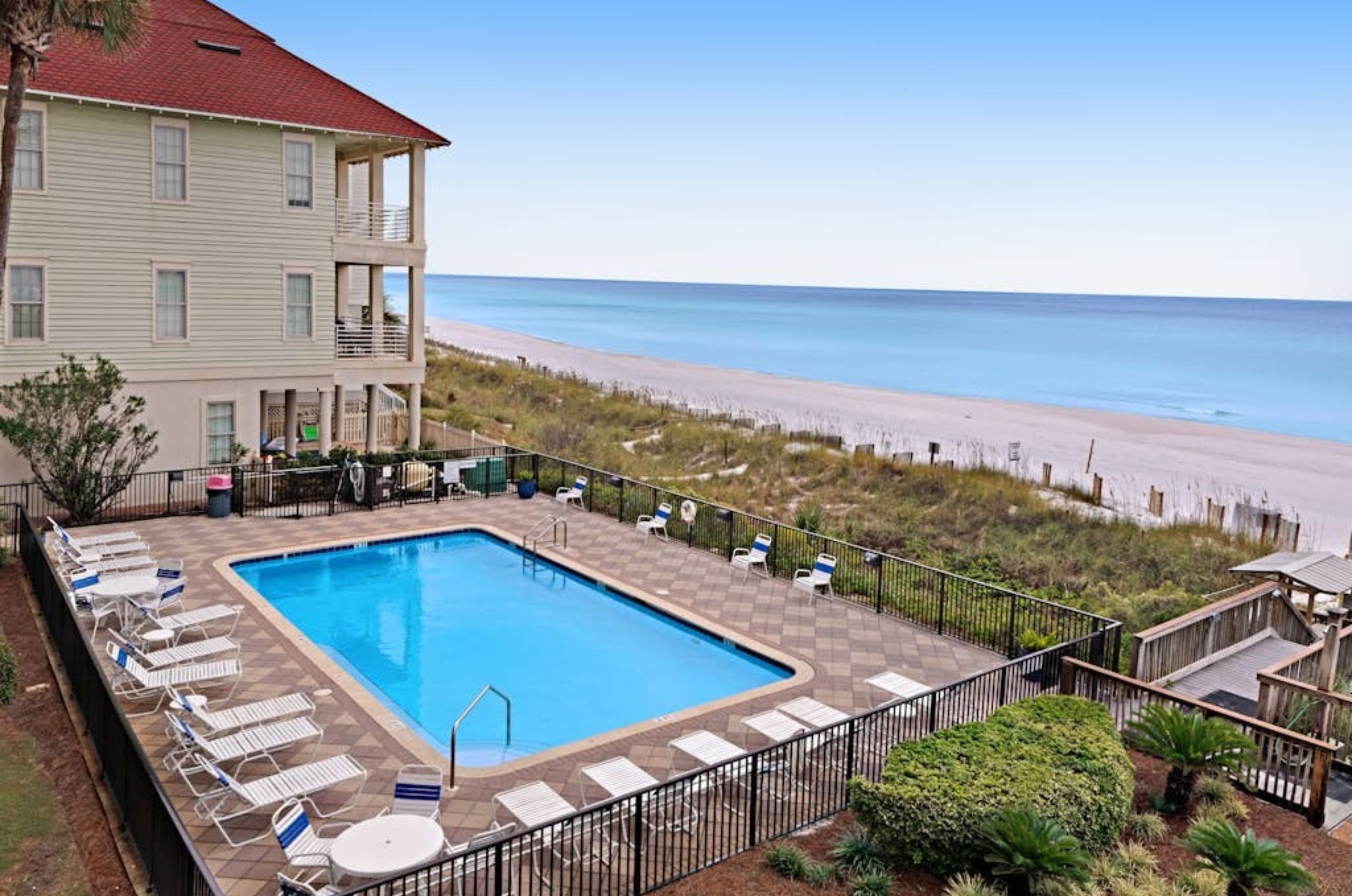 A balcony view of Huntington by the Sea's beachside swimming pool spacious sundeck and boardwalk to the beach