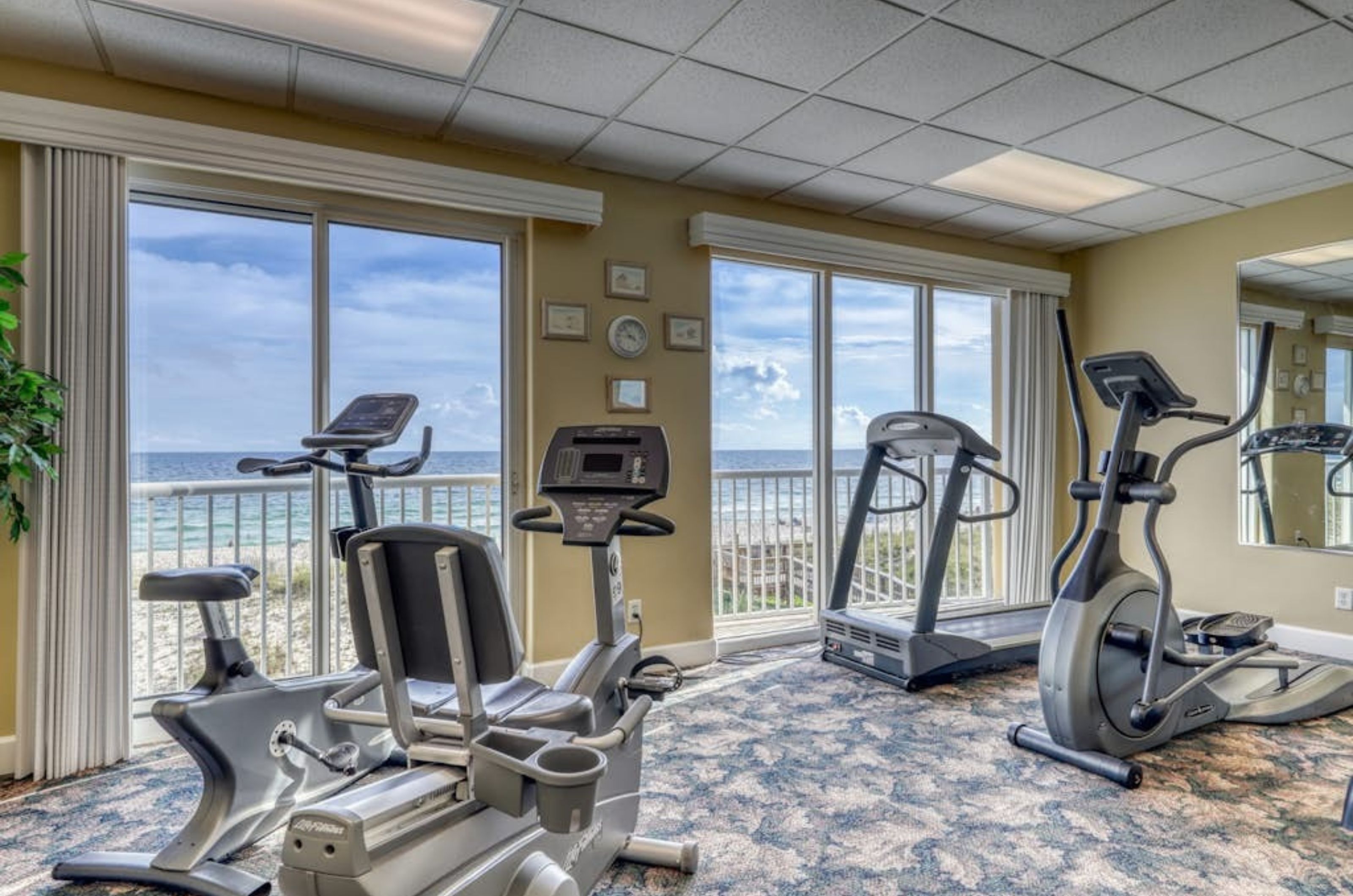 Cardio equipment in the gym at Island Royale next to Gulf-facing windows
