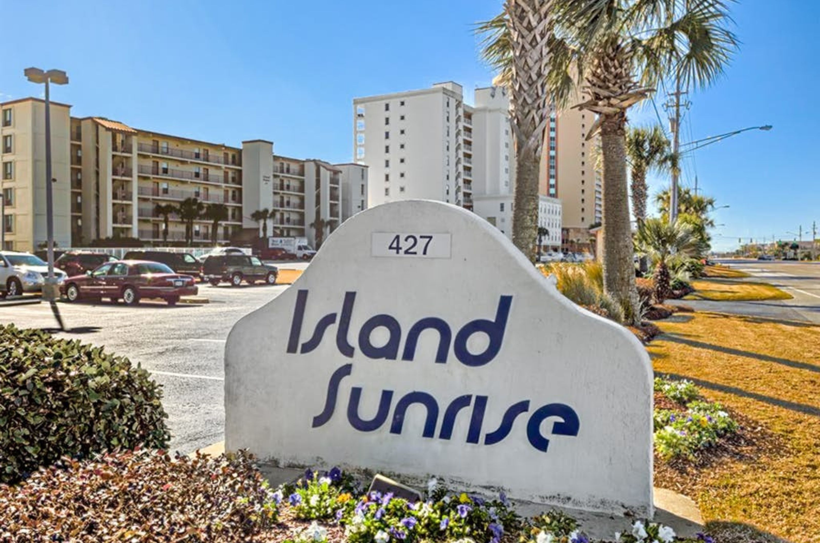 View from the street of Island Sunrise with the property's entry sign out front 