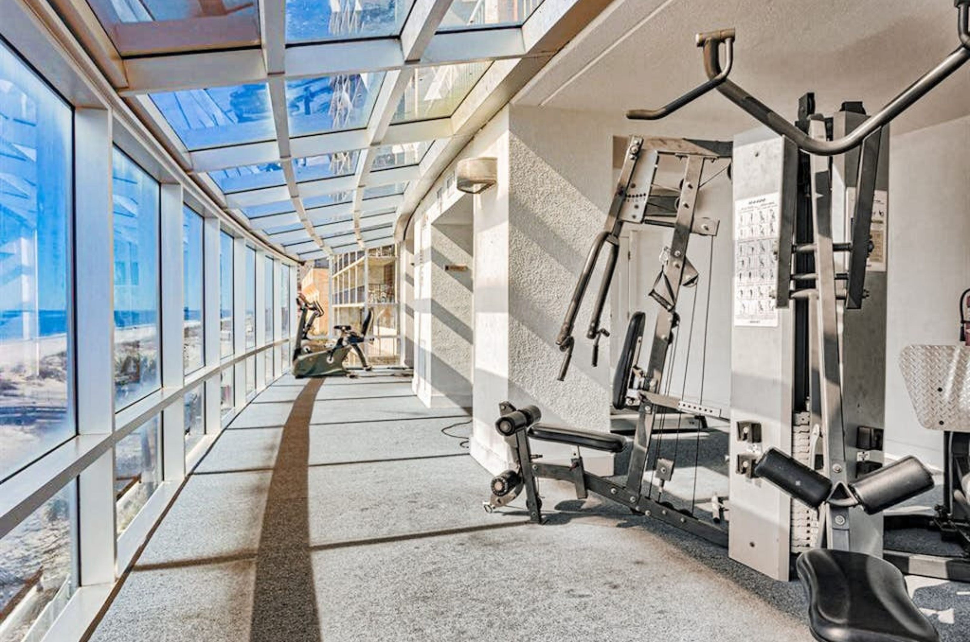 Strength equipment in the gym next to floor to ceiling windows overlooking the Gulf 