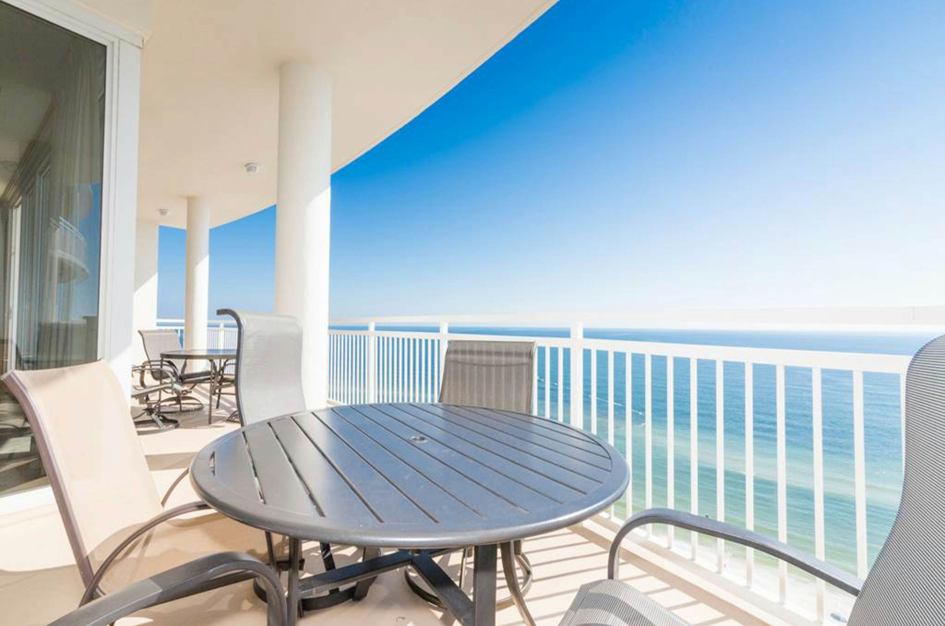 View of the Gulf of Mexico from a private balcony with a dining table and chairs 