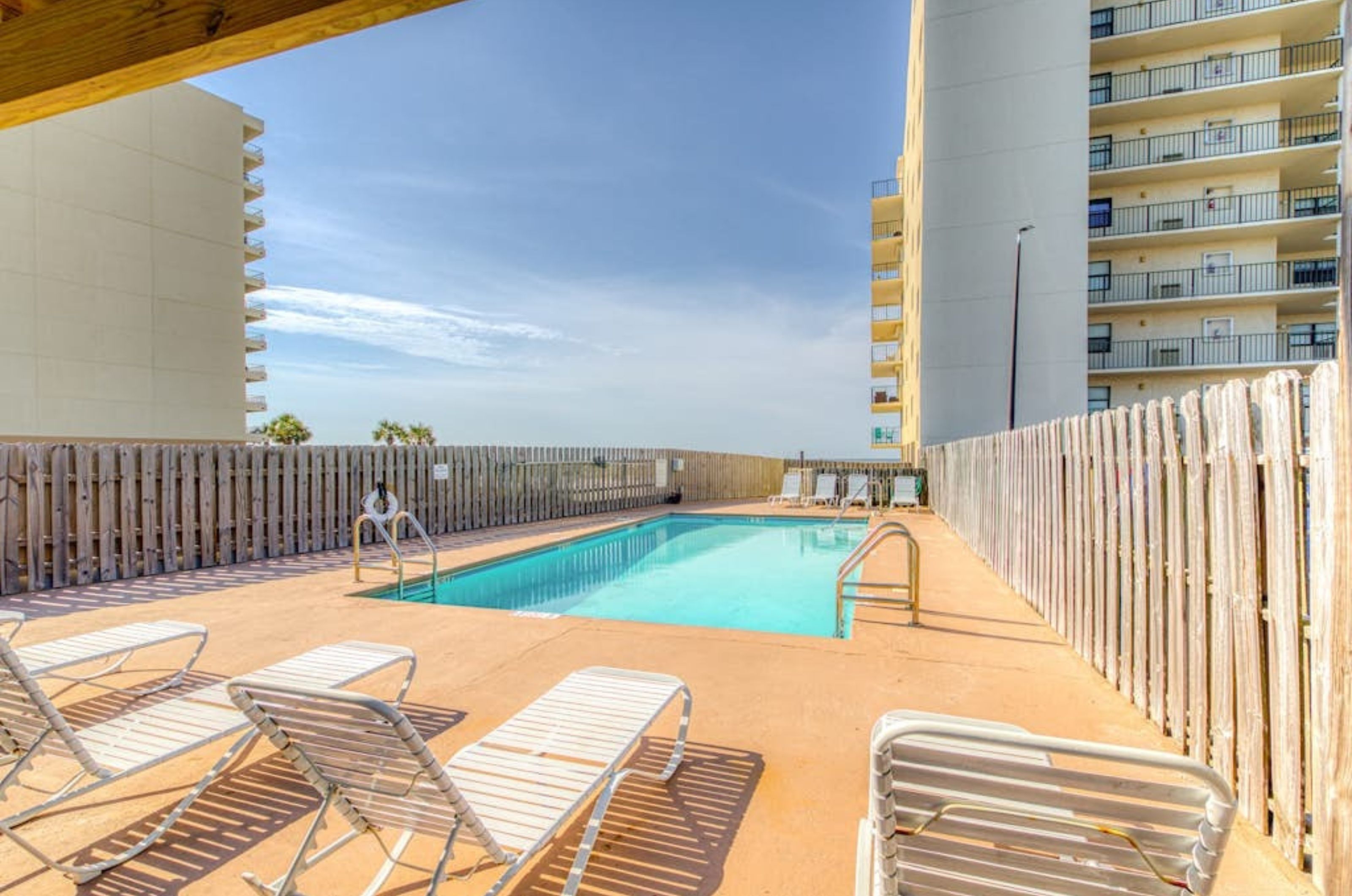 Lounge chairs next to the outdoor swimming pool at Lei Lani in Orange Beach Alabama 