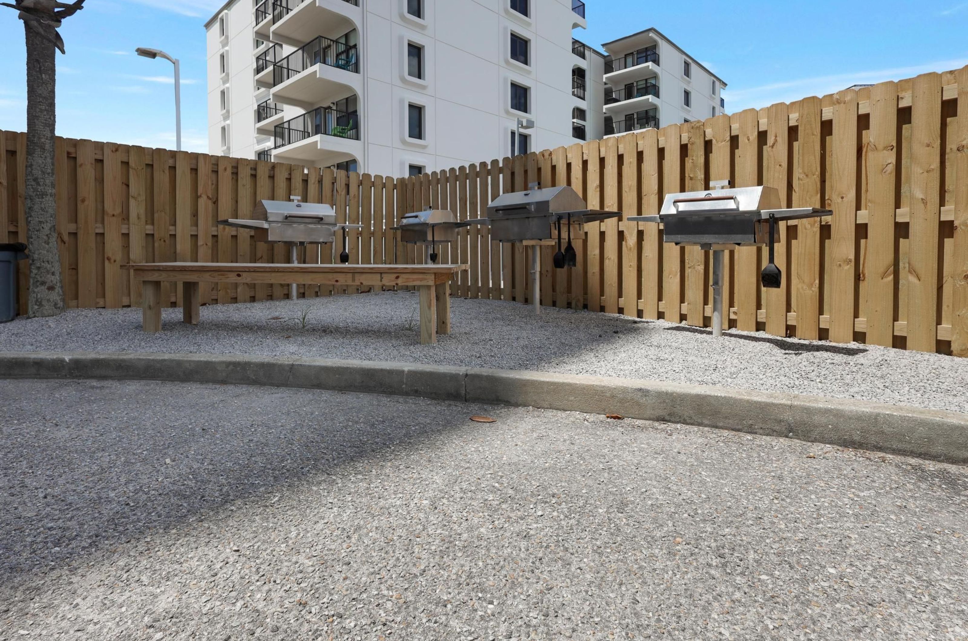 Outdoor barbecue grills on a fenced-in patio at Lighthouse Condominiums 