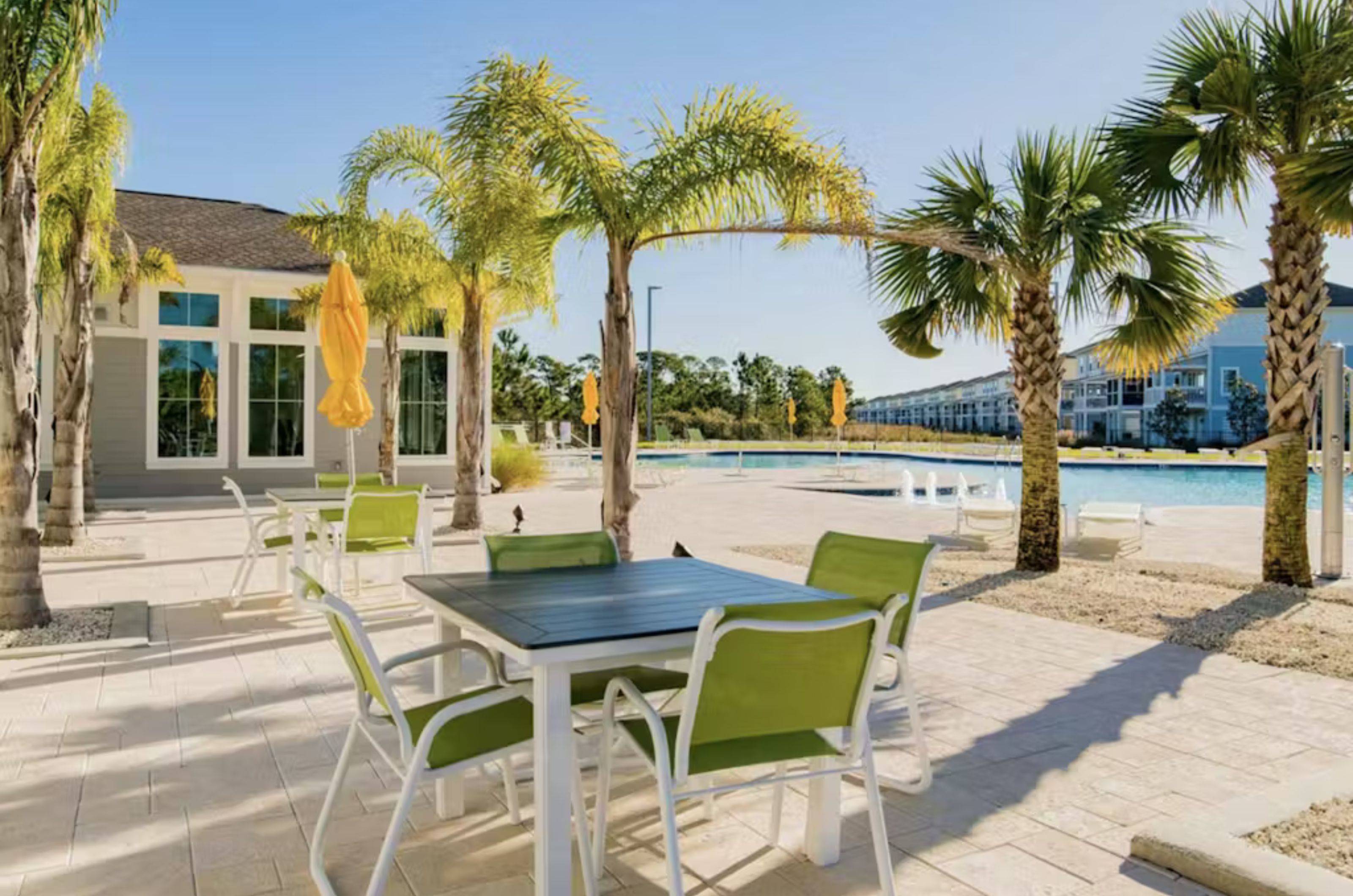 Table and chairs next to the large outdoor pool and fitness center 