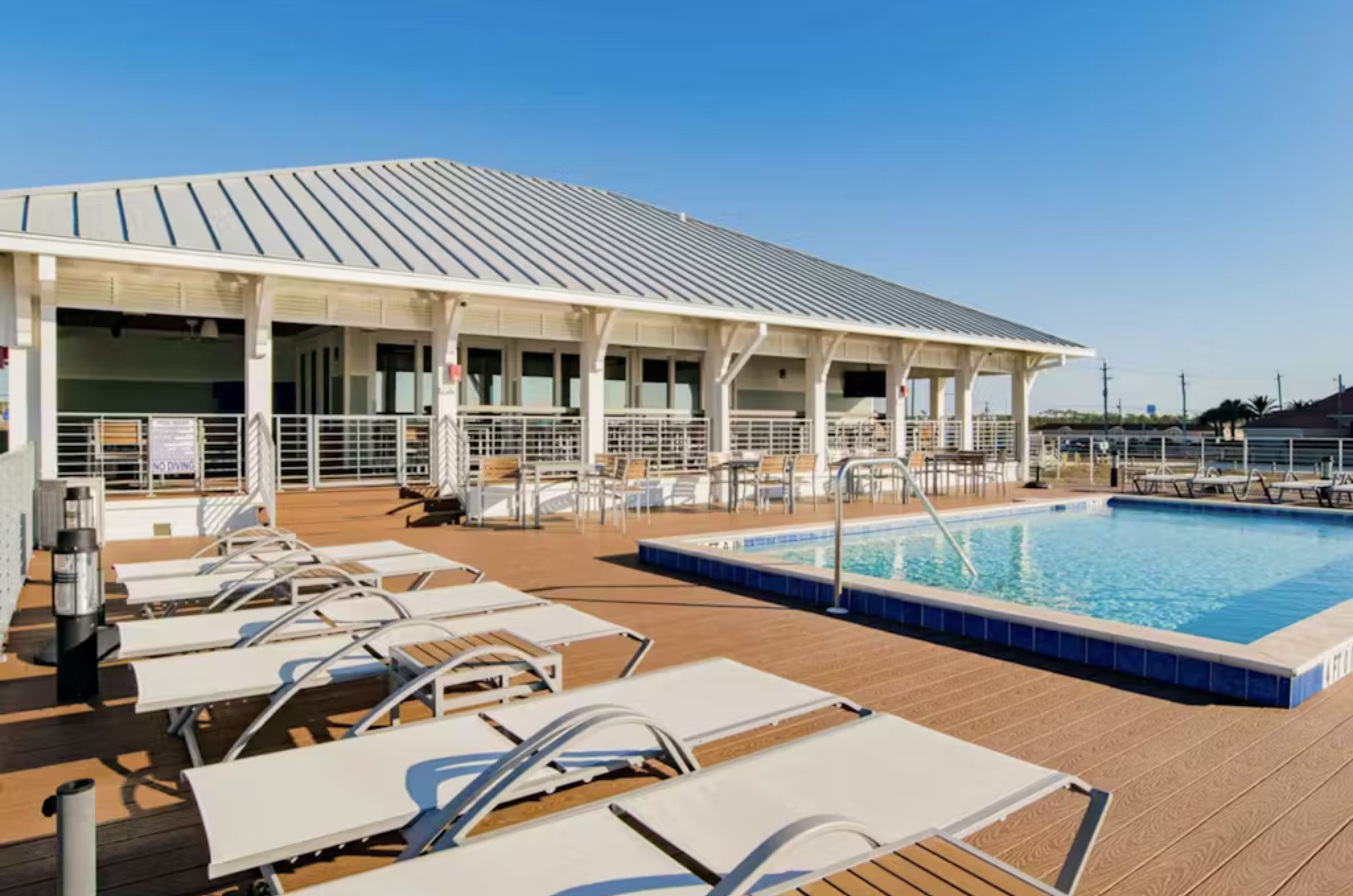 The beachfront swimming pool at the Beach Club with white lounge chairs 