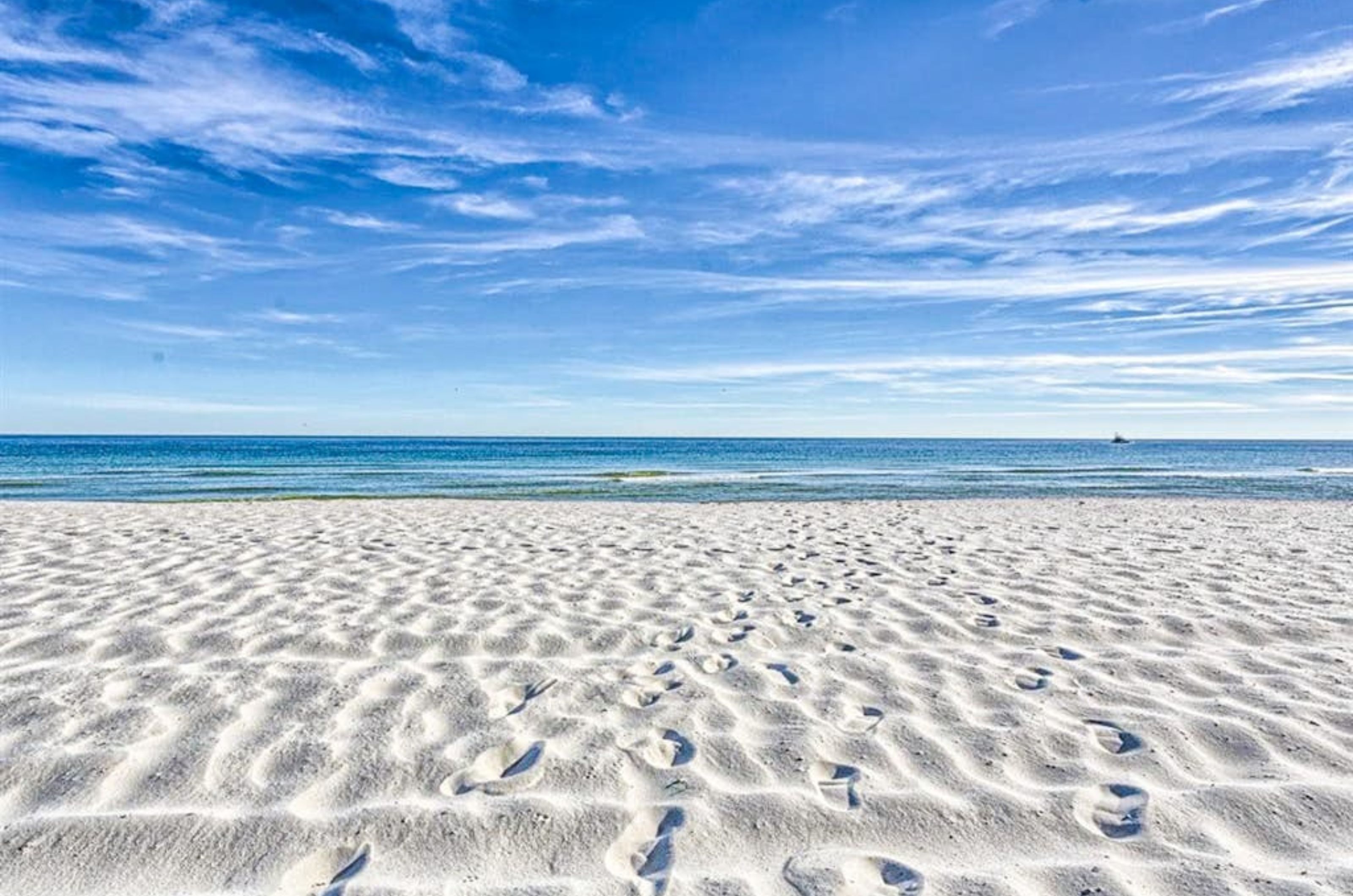 The white sandy beaches in front of the water in Orange Beach Alabama