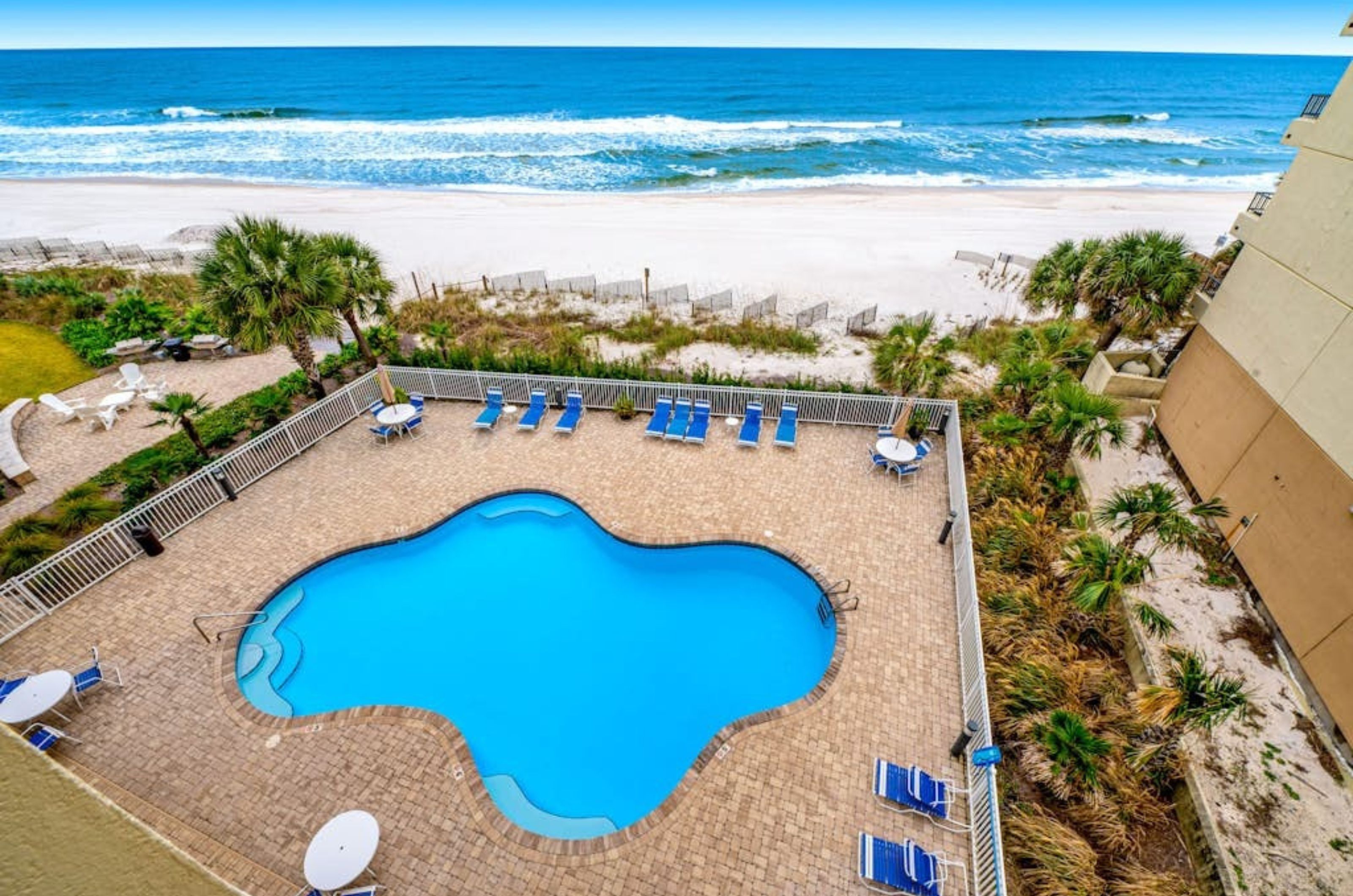 Aerial view of the outdoor pool and pool deck next to the beach at Marlin Key