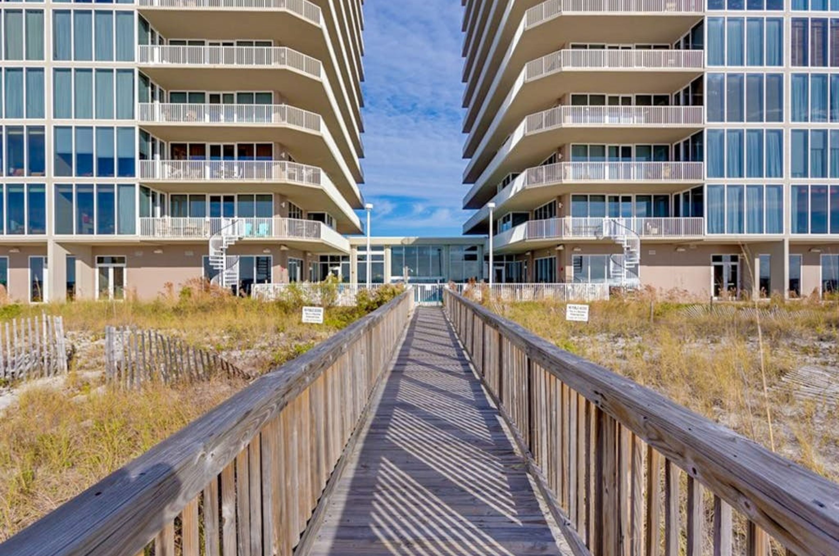 The boardwalk to the beach in front of the lower exterior of Mediterranean Condos