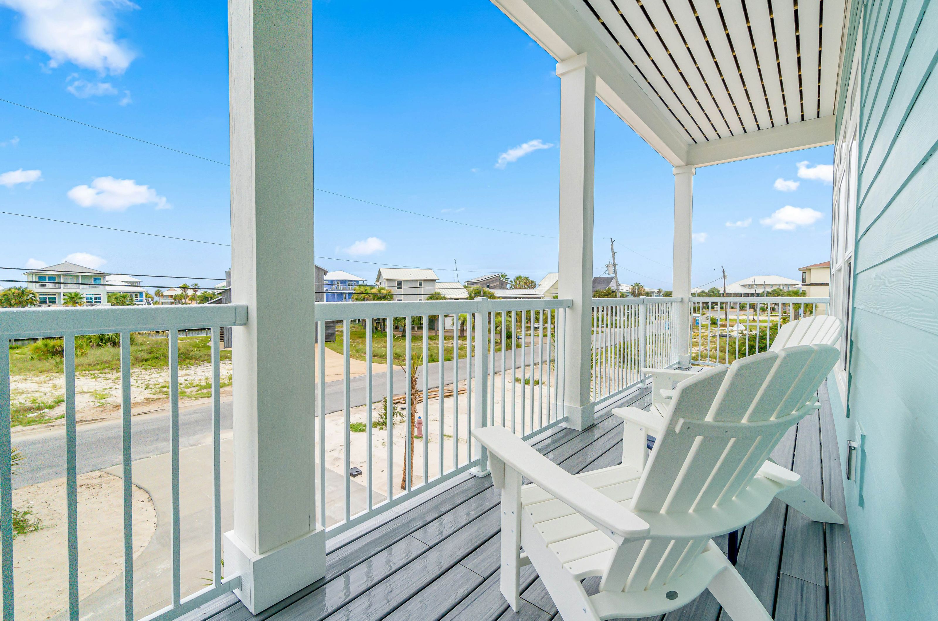 Outdoor porch with a lounge chair overlooking the street and sand