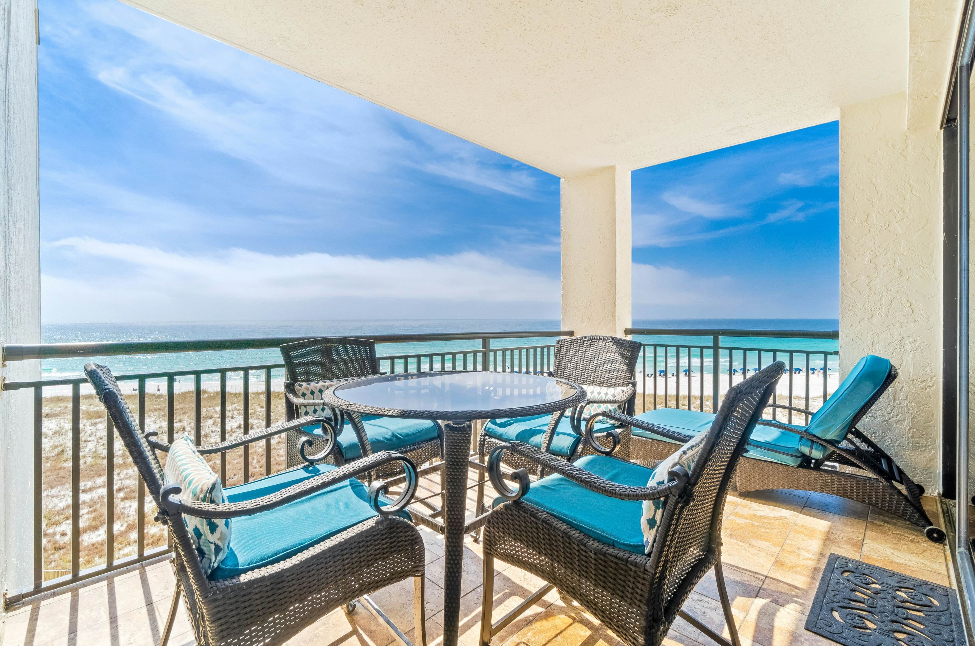 Dining chairs and one table on a private balcony overlooking the beach