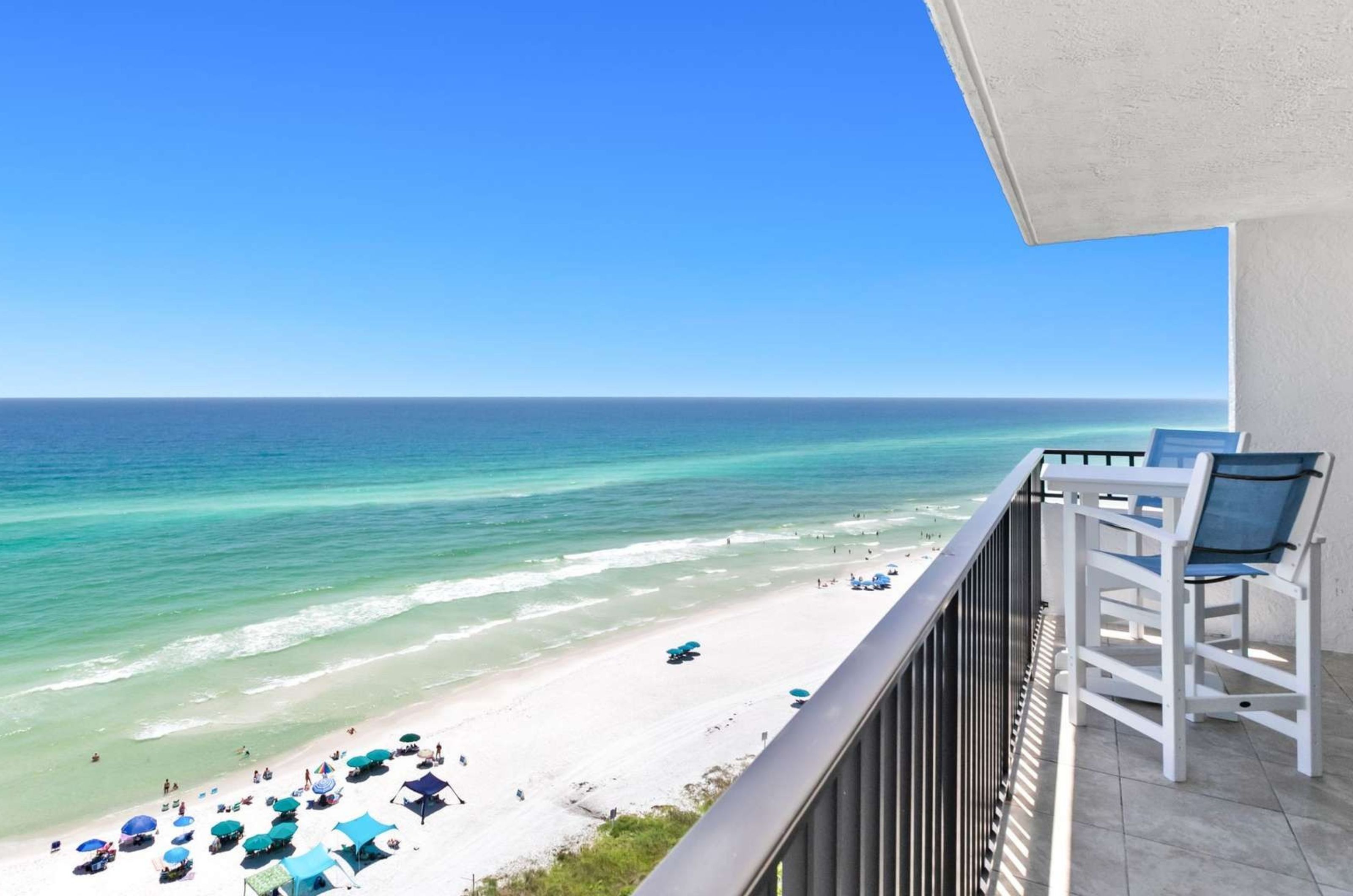 A private balcony overlooking the Gulf with a chair and table at One Seagrove Place 