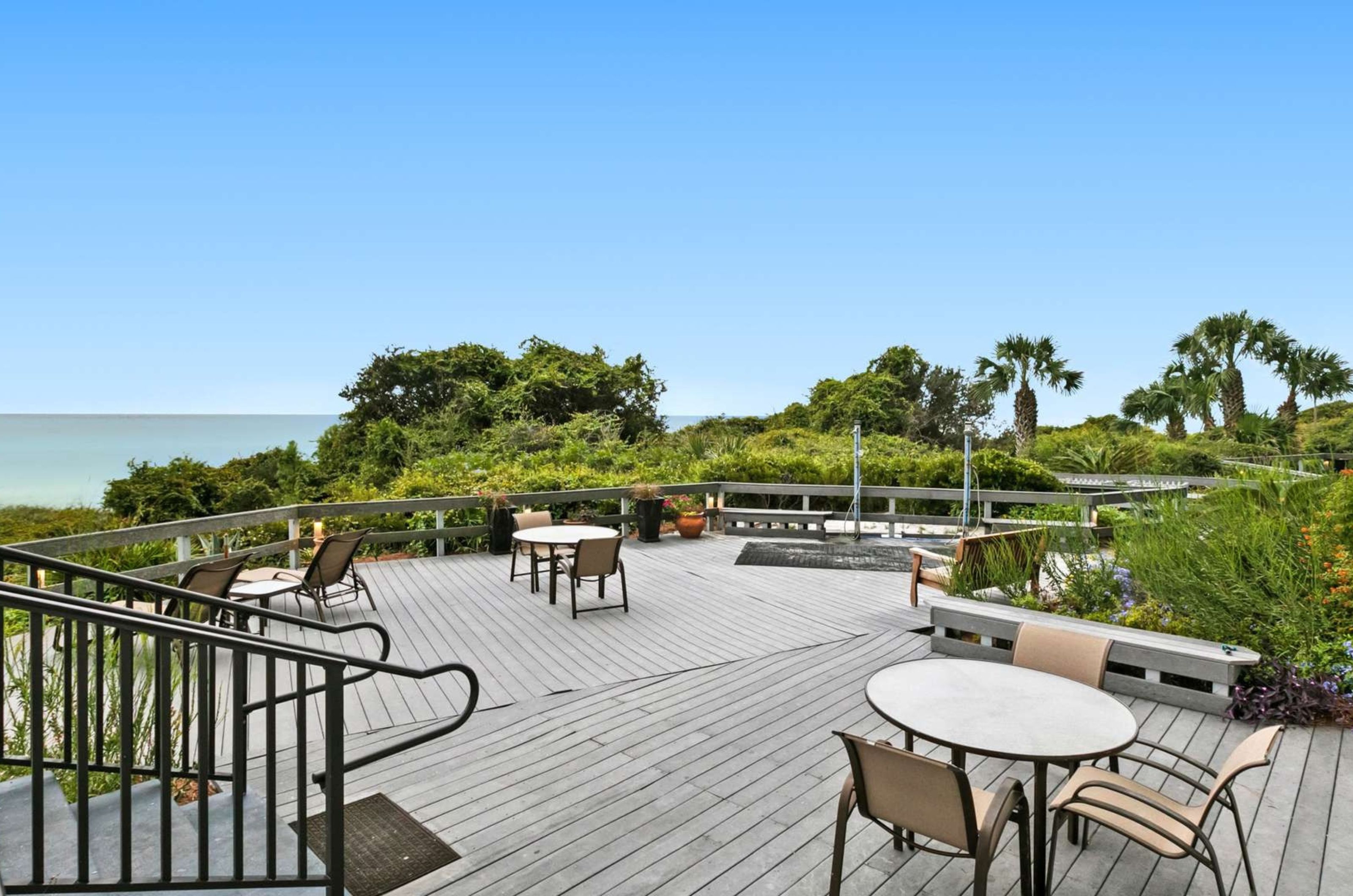 Tables and chairs on the beachside patio at One Seagrove Place