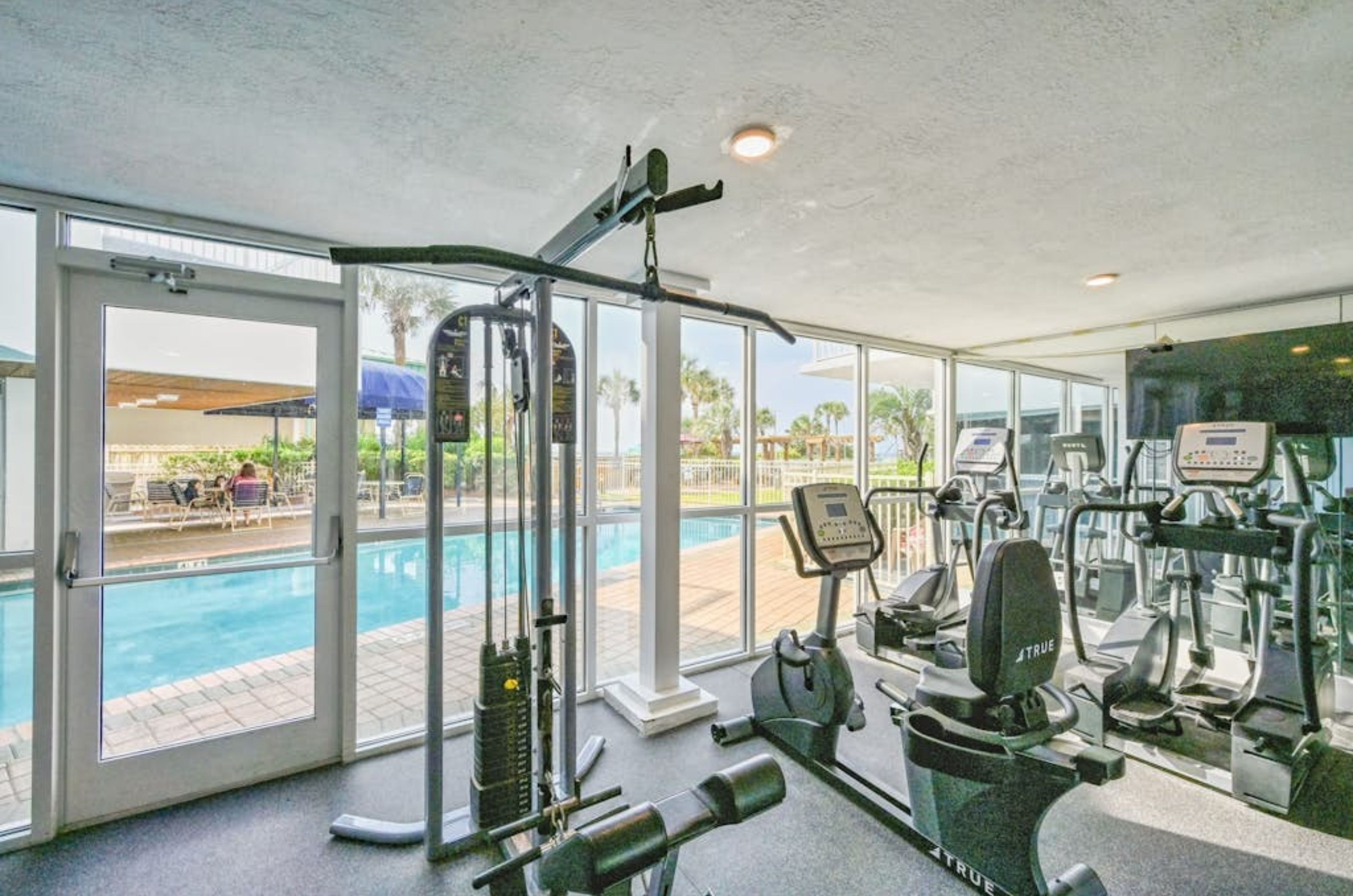 Fitness equipment with windows overlooking the pool at Pelican Beach Resort in Destin Florida 