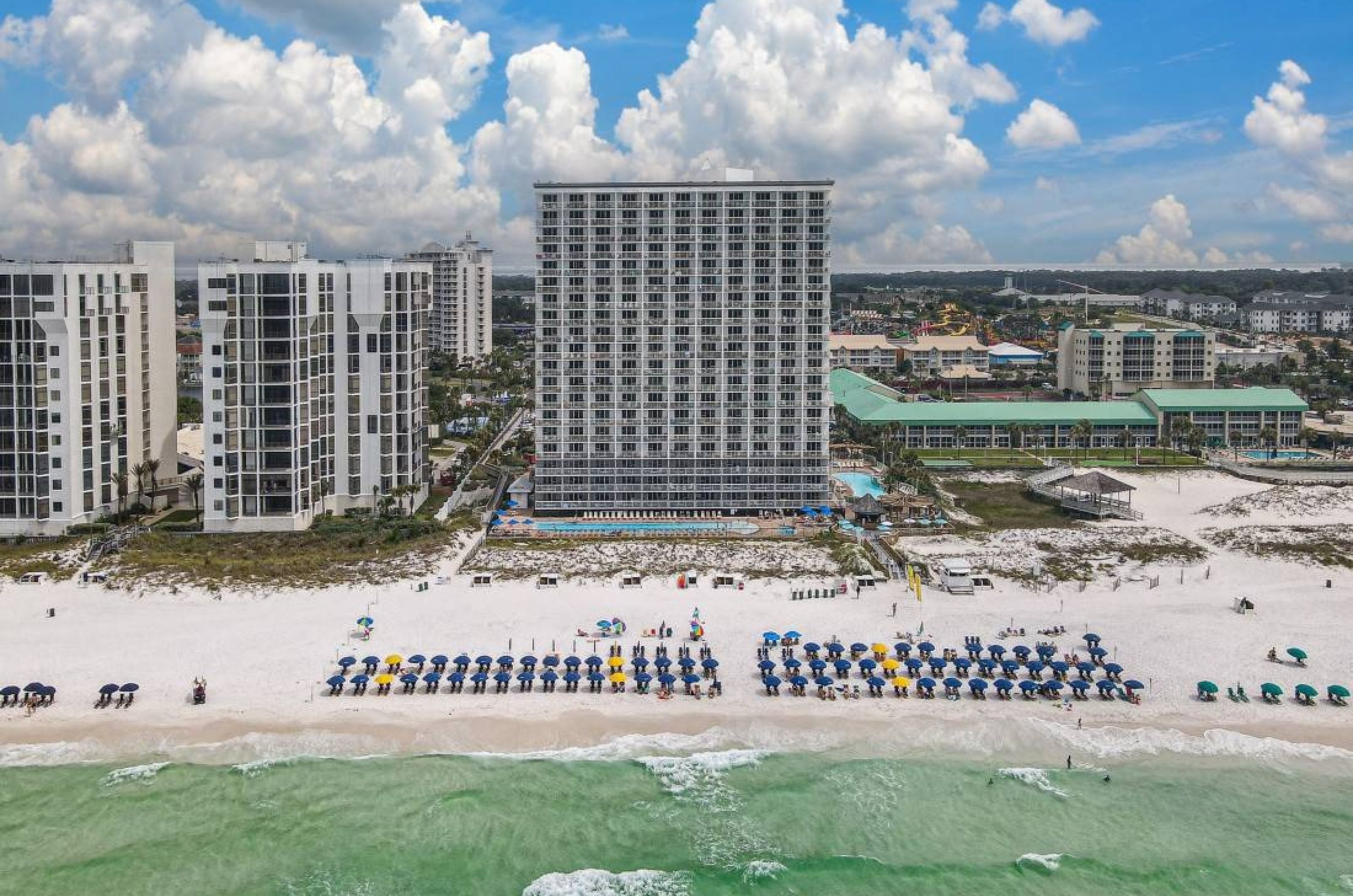 View of the Gulf-front facade of Pelican Beach Resort with the beach in front 