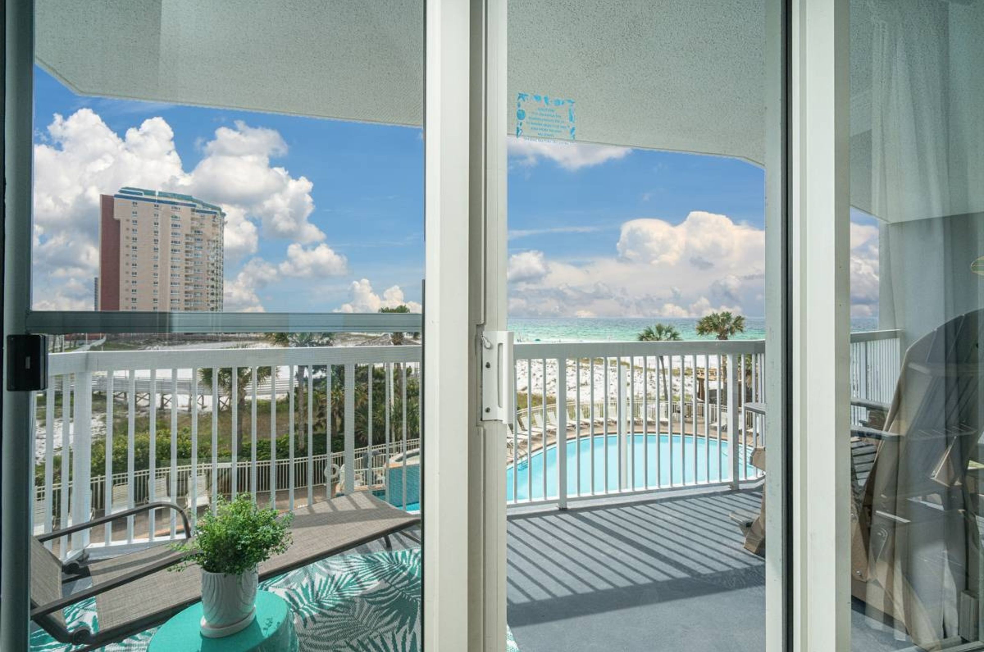 A sliding door leading to a private balcony that overlooks the Gulf and the pool deck 