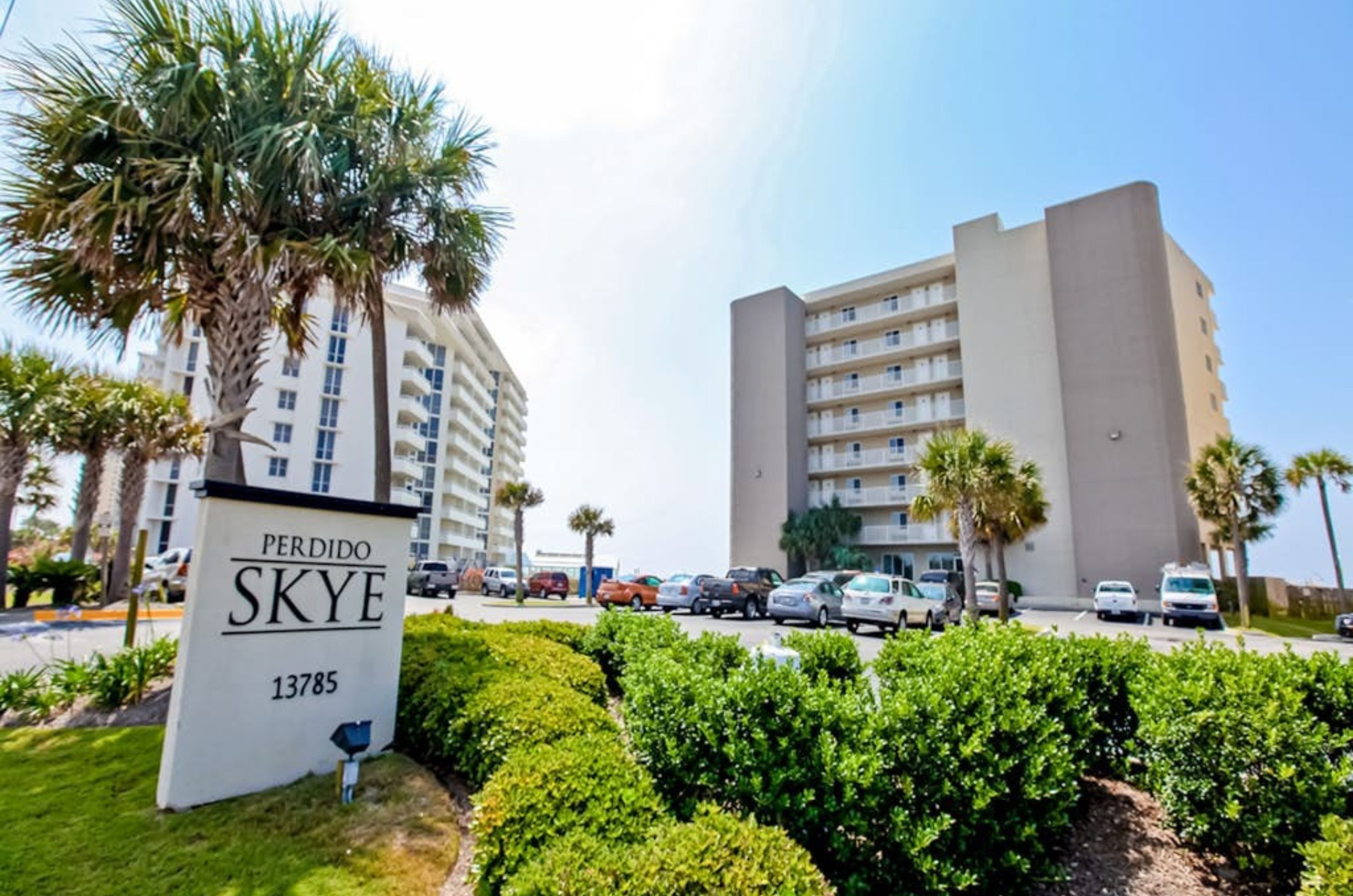 View from the street of Perdido Skye and the property's entry sign with complimentary parking in front 