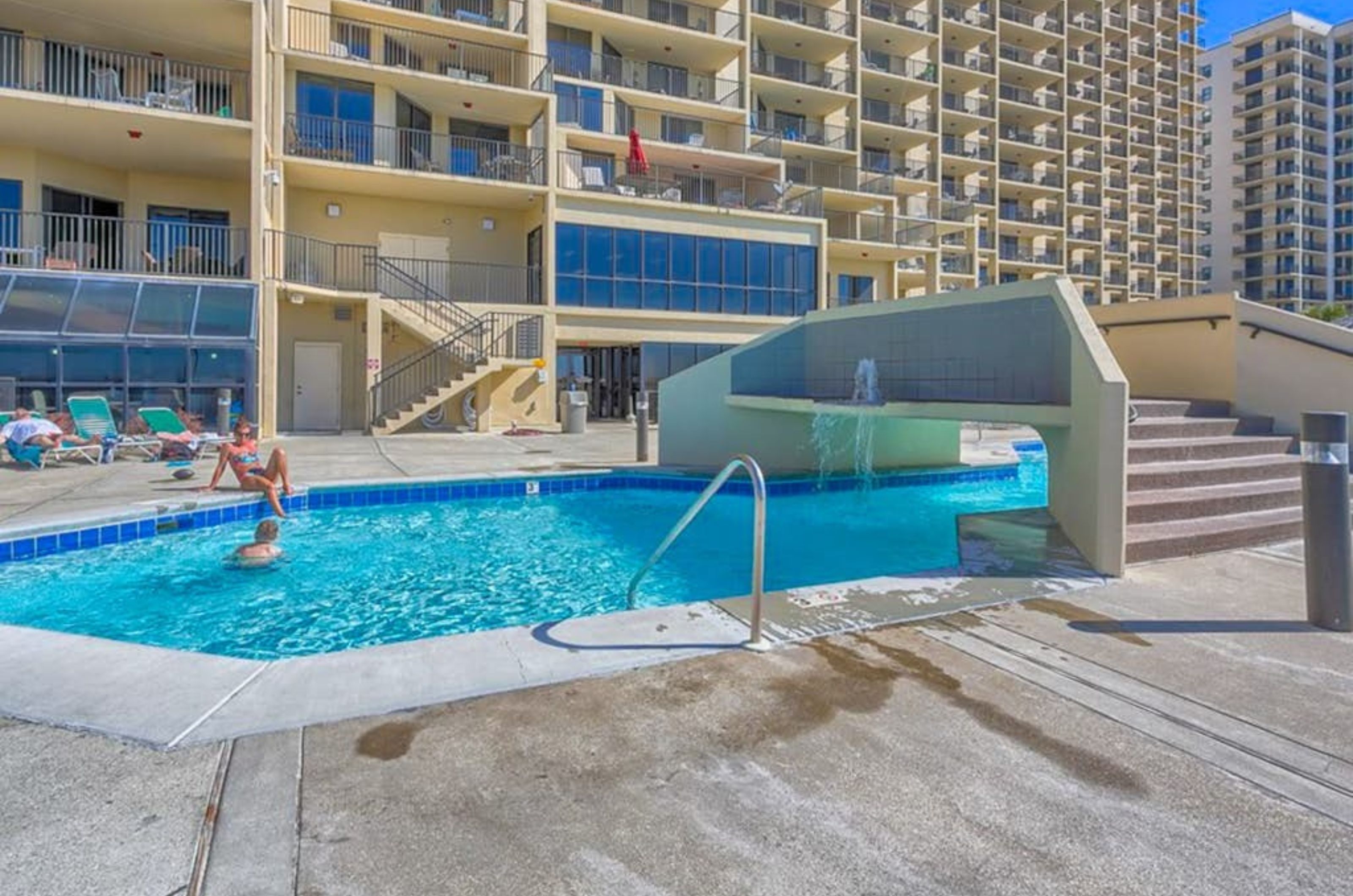 The spacious outdoor pool with a bridge at Phoenix VII in Orange Beach Alabama 