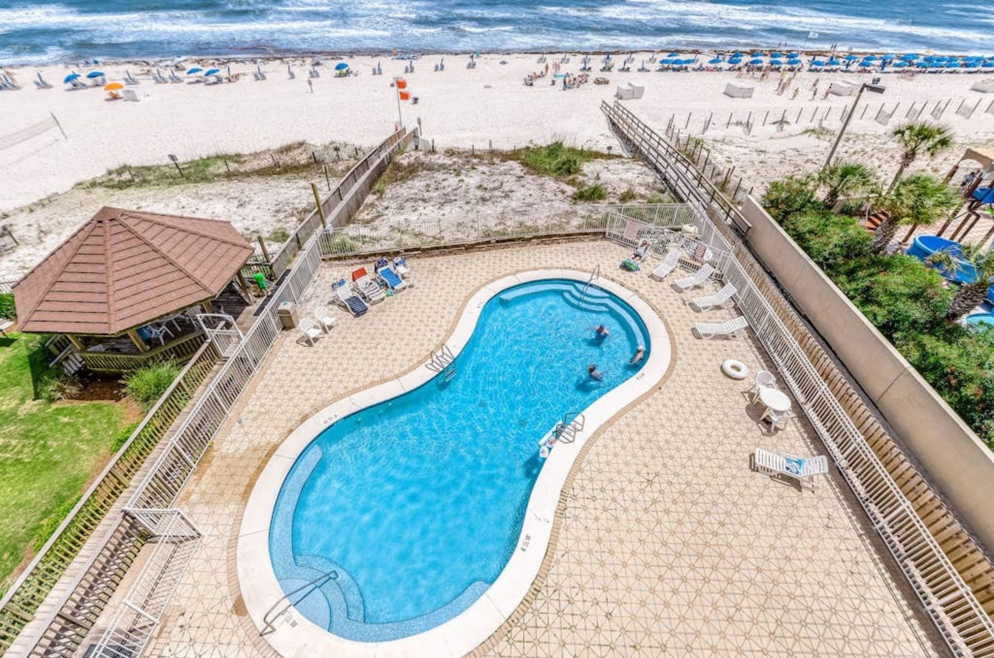 View from a balcony of the pool and boardwalk next to the beach at Romar Tower 