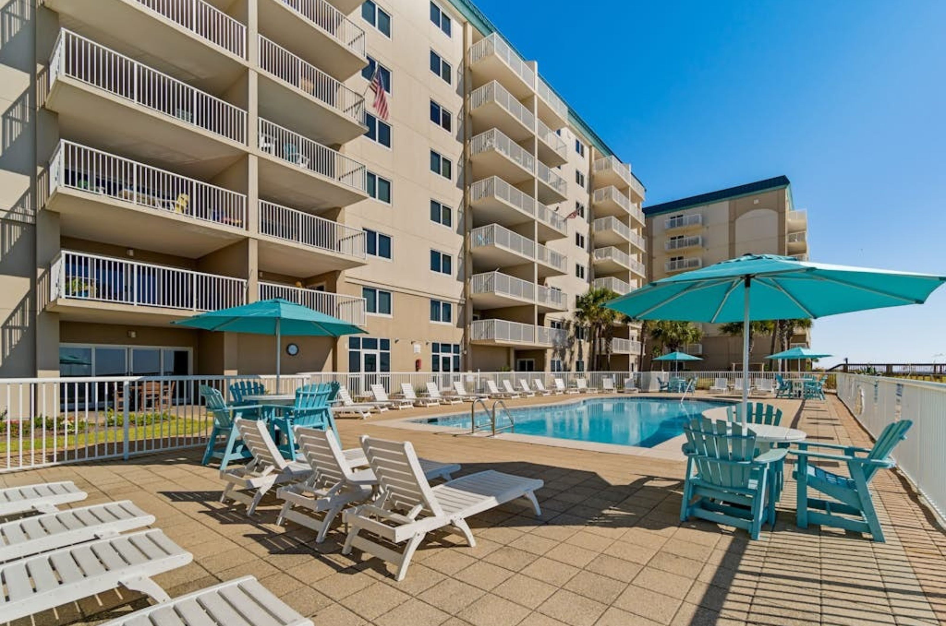 The beachside pool with lounge chairs and umbrellas on the surrounding pool deck 