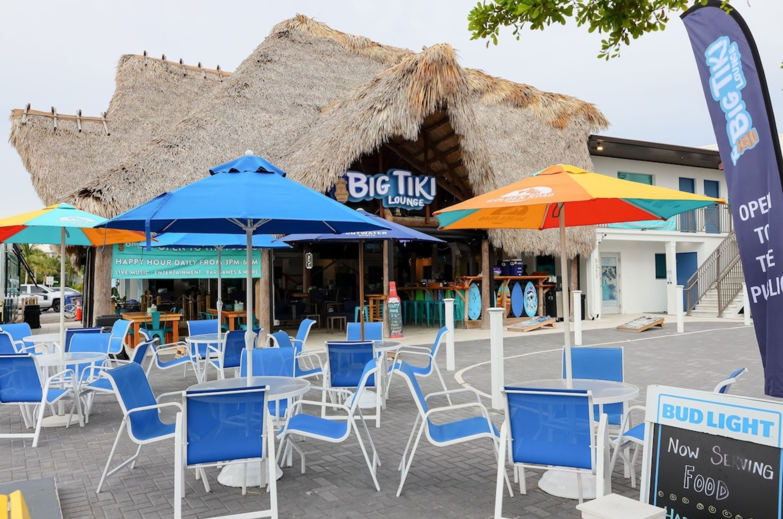 The exterior of the restaurant in front of the hotel with dining chairs and tables 