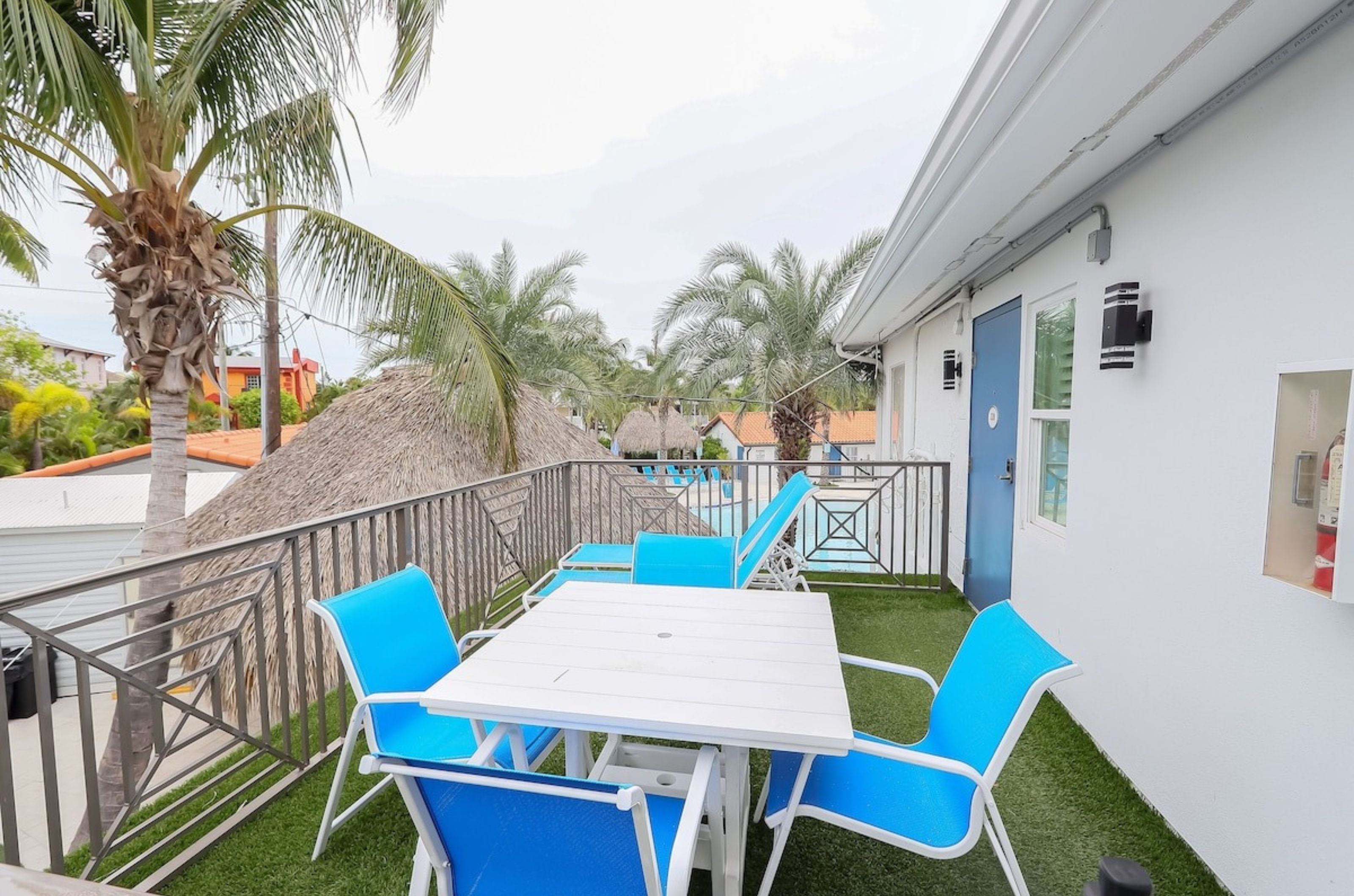 An outdoor patio at Siesta Key Beach Resort and Suites with a table and lounge chairs 