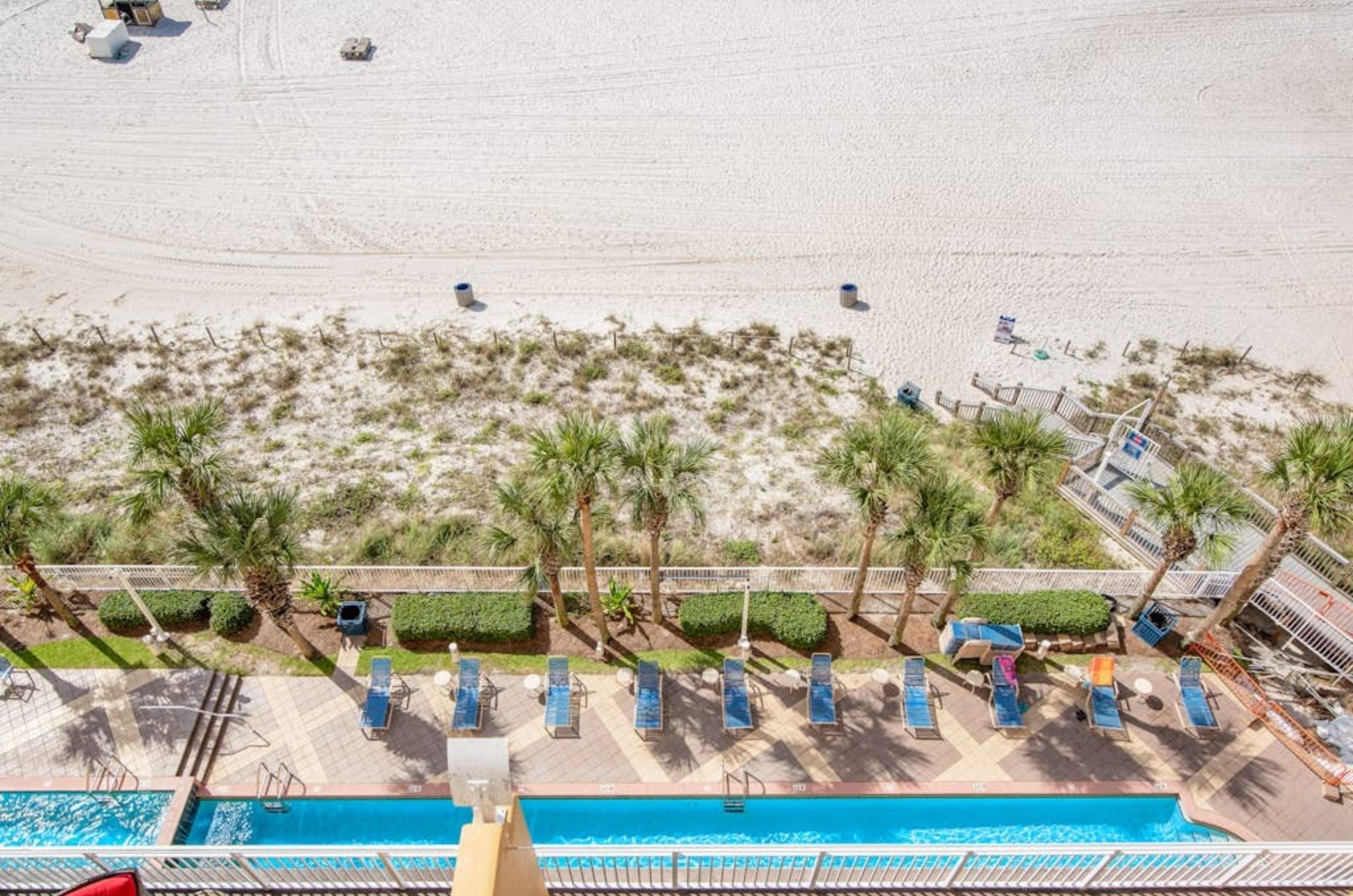 View of the beachside pool deck and boardwalk to the beach from a private balcony 