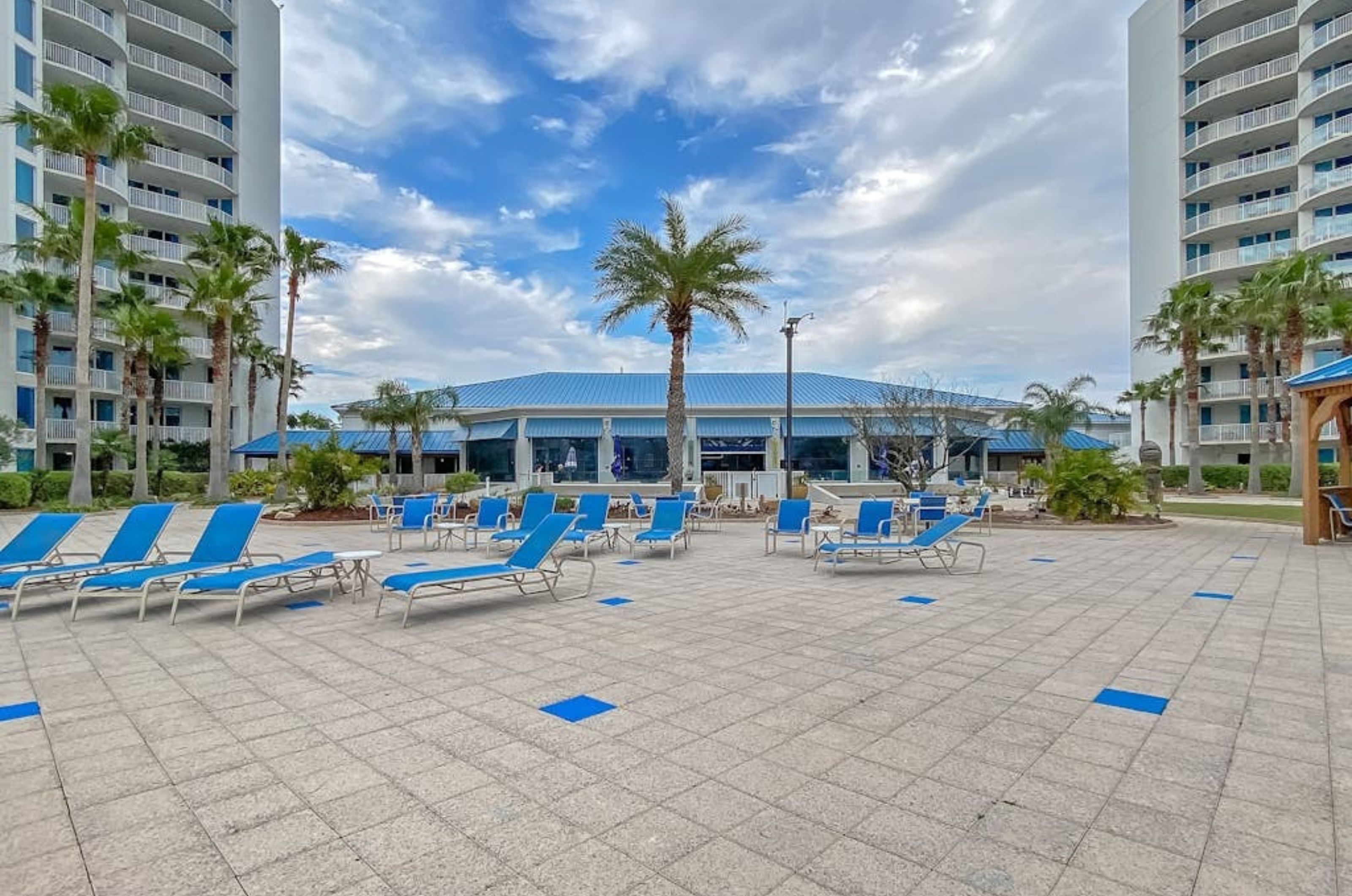 The spacious pool deck at the Palms of Destin with lounge chairs 